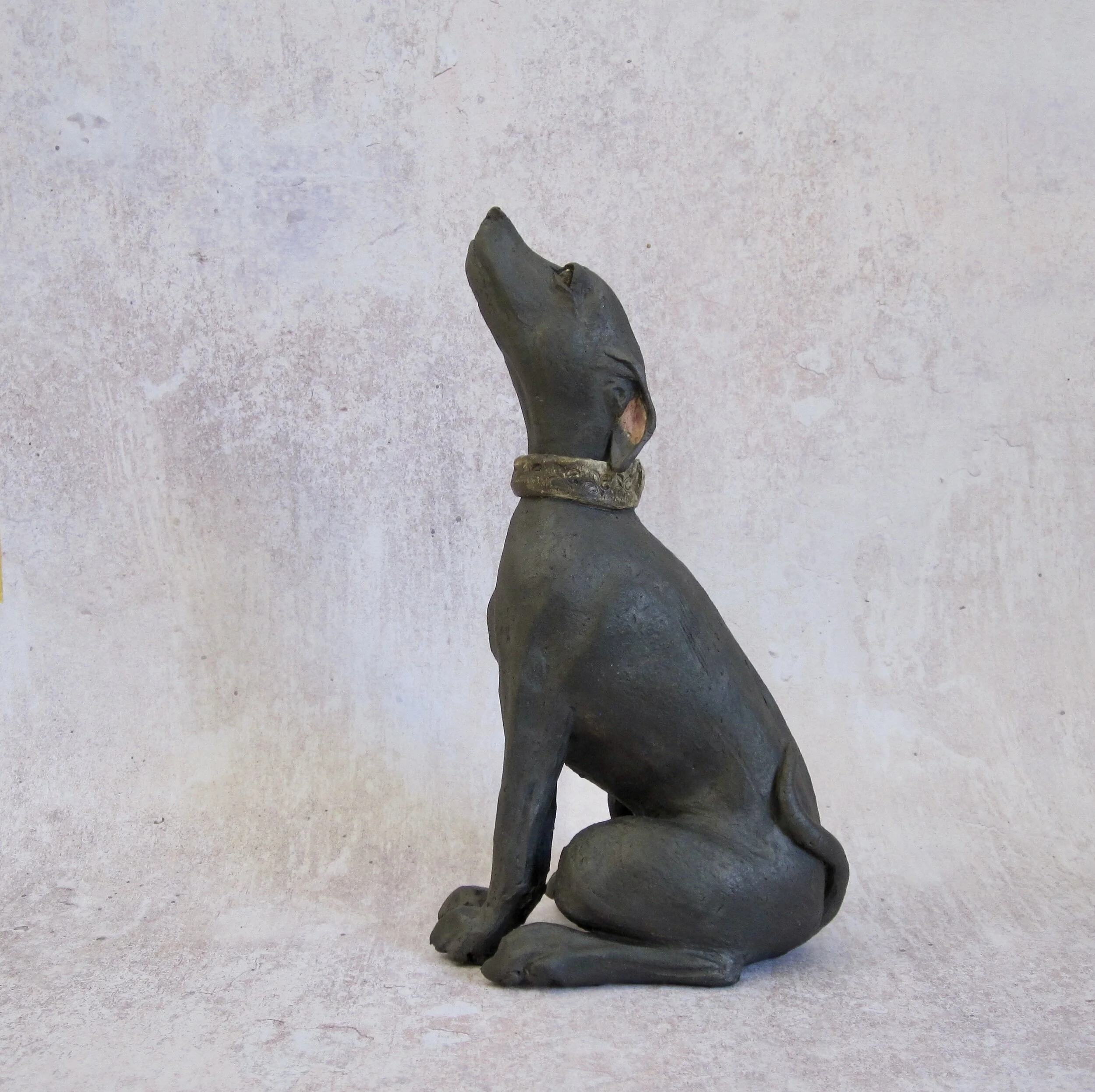 Individual handmade, sculpted black dog, reverse side view