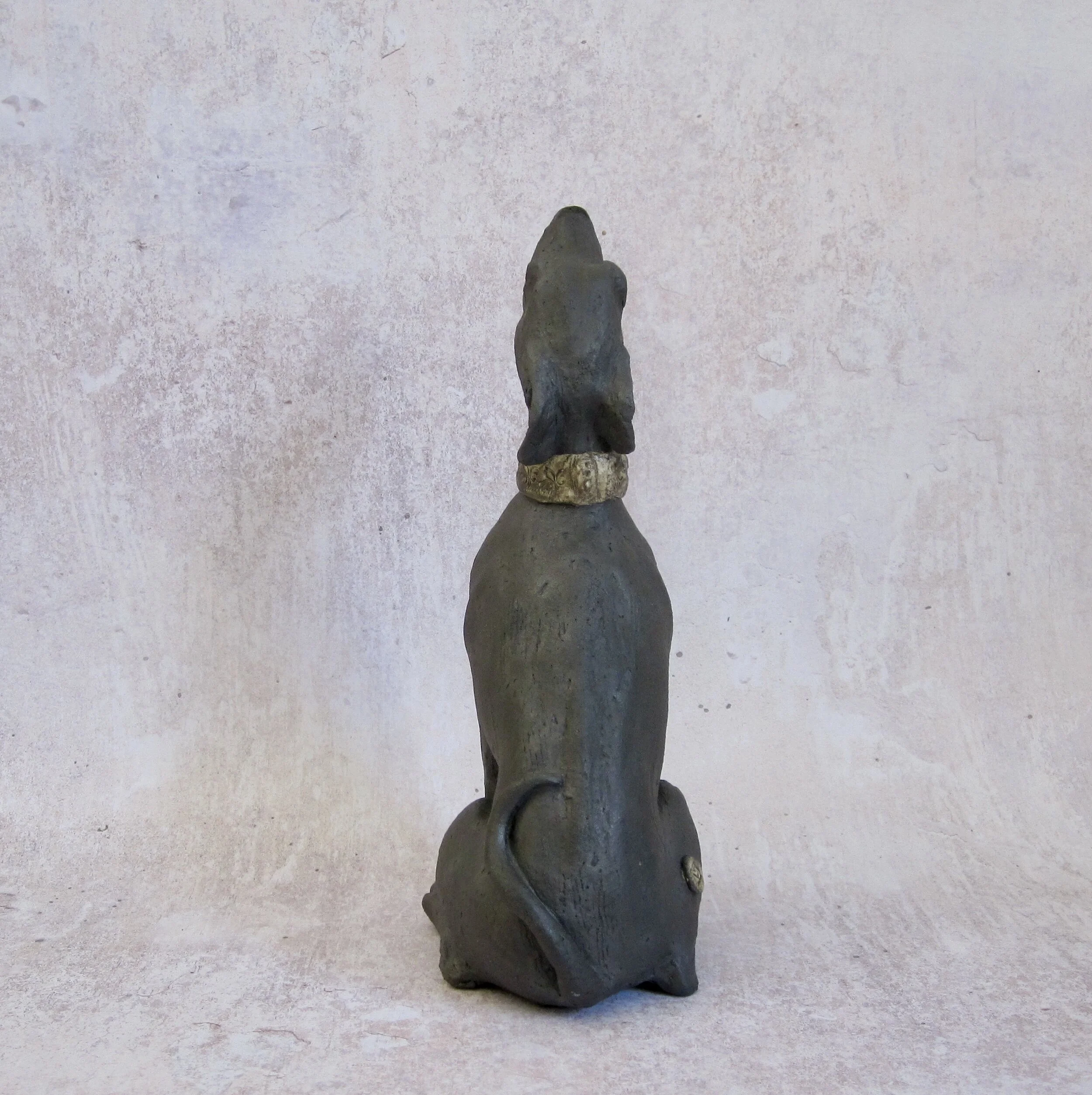 Individual handmade, sculpted black dog, back view