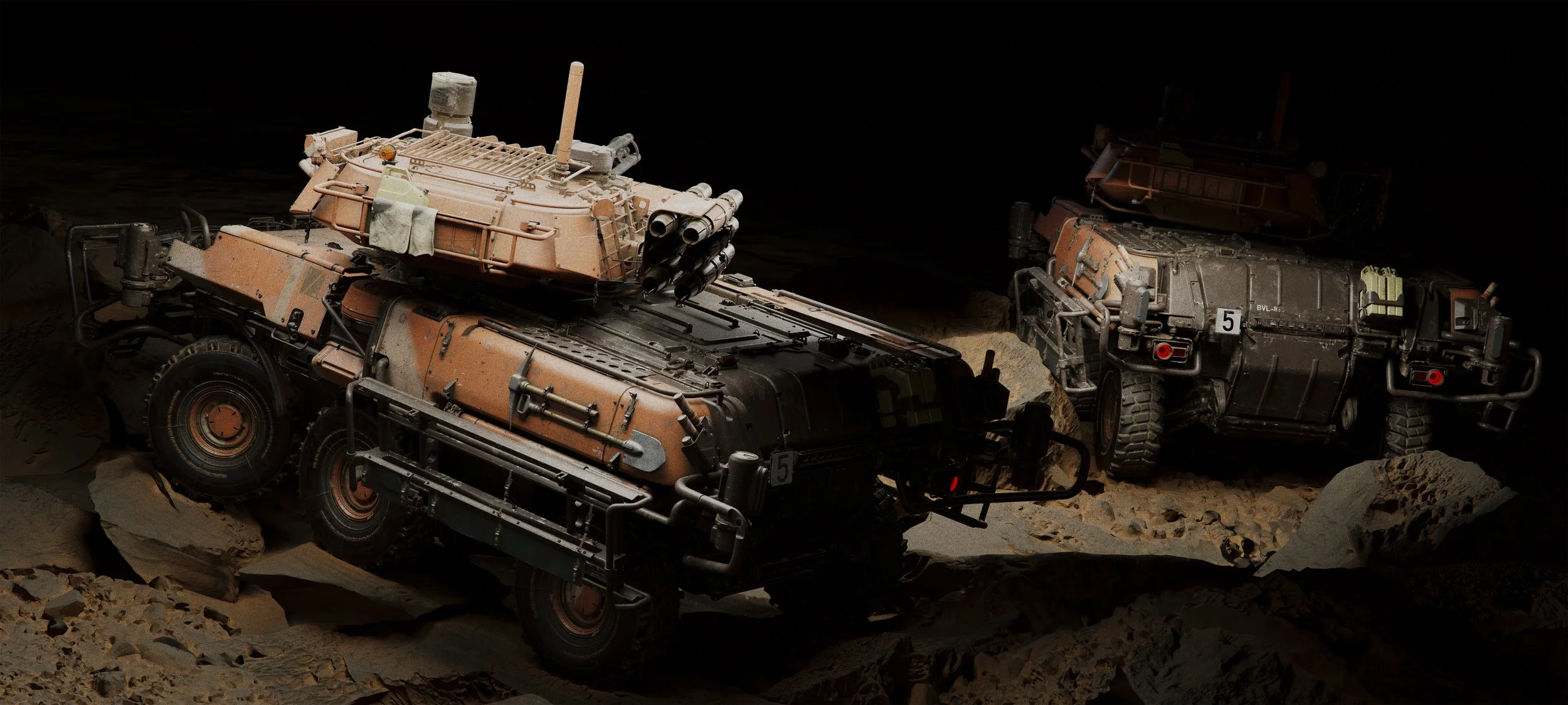 Two military vehicles, resembling tanks or armored trucks, are positioned on a rocky, desert-like terrain with a dark background. They are equipped with large wheels, and the one on the left has a mounted missile launcher on top.