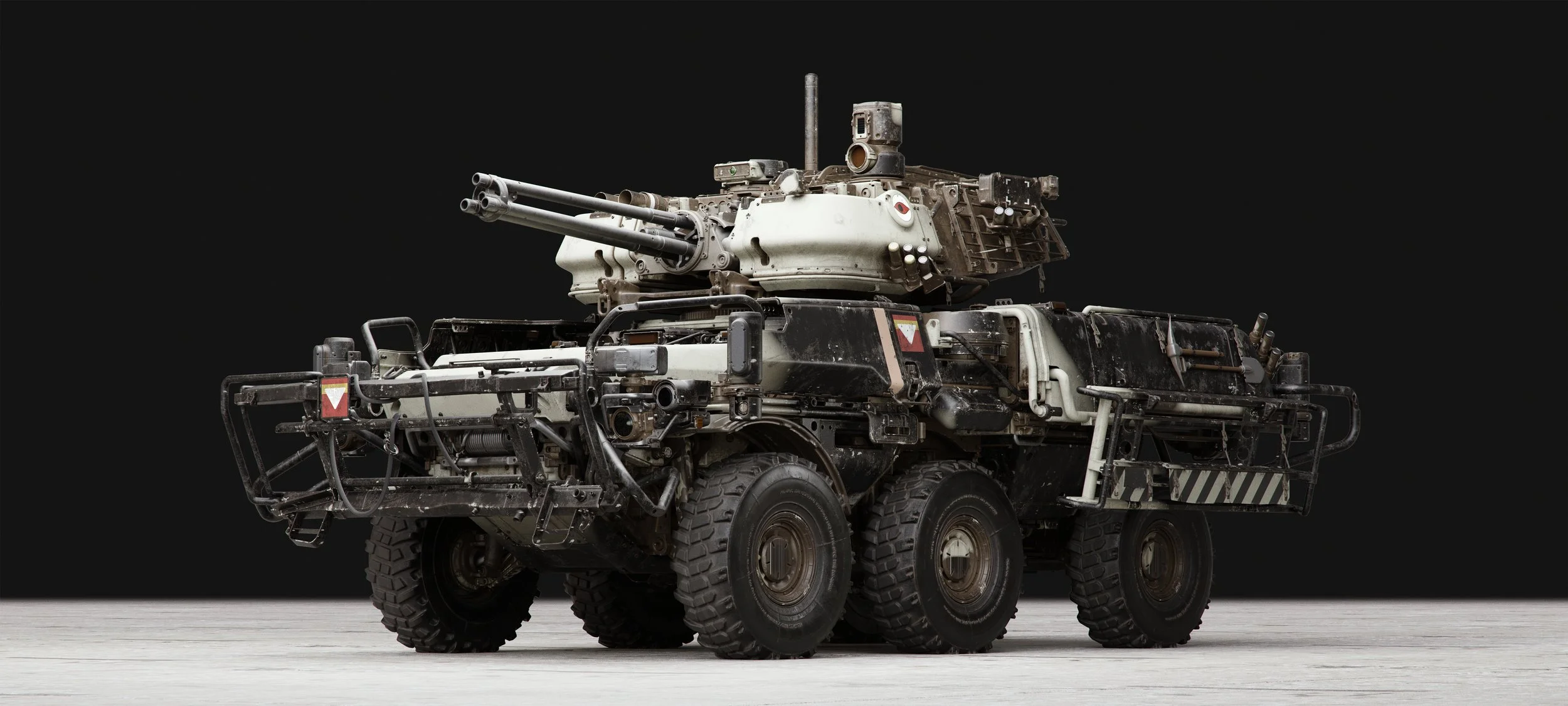 Military armored vehicle with a turret and large tires, positioned on a light-colored surface with a black background.