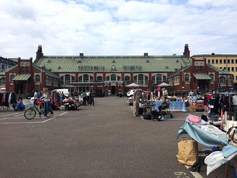   A flea market outside of a market hall.  