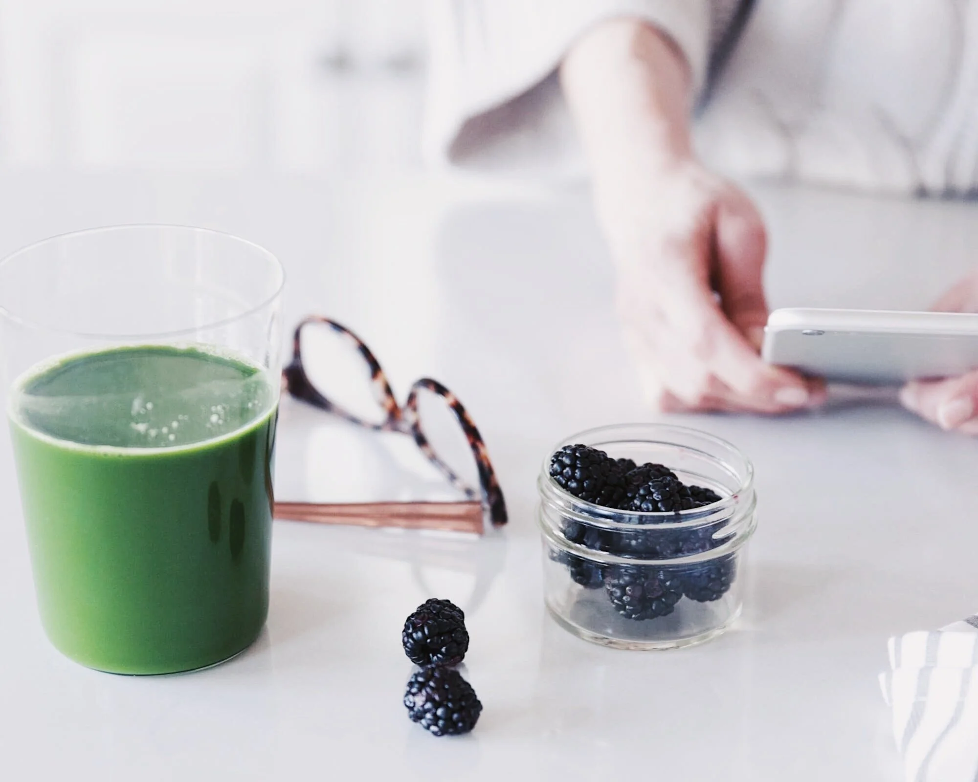 “Healthy workspace with green juice and berries — simple nutrition that supports energy, focus and creative productivity for entrepreneurs.”