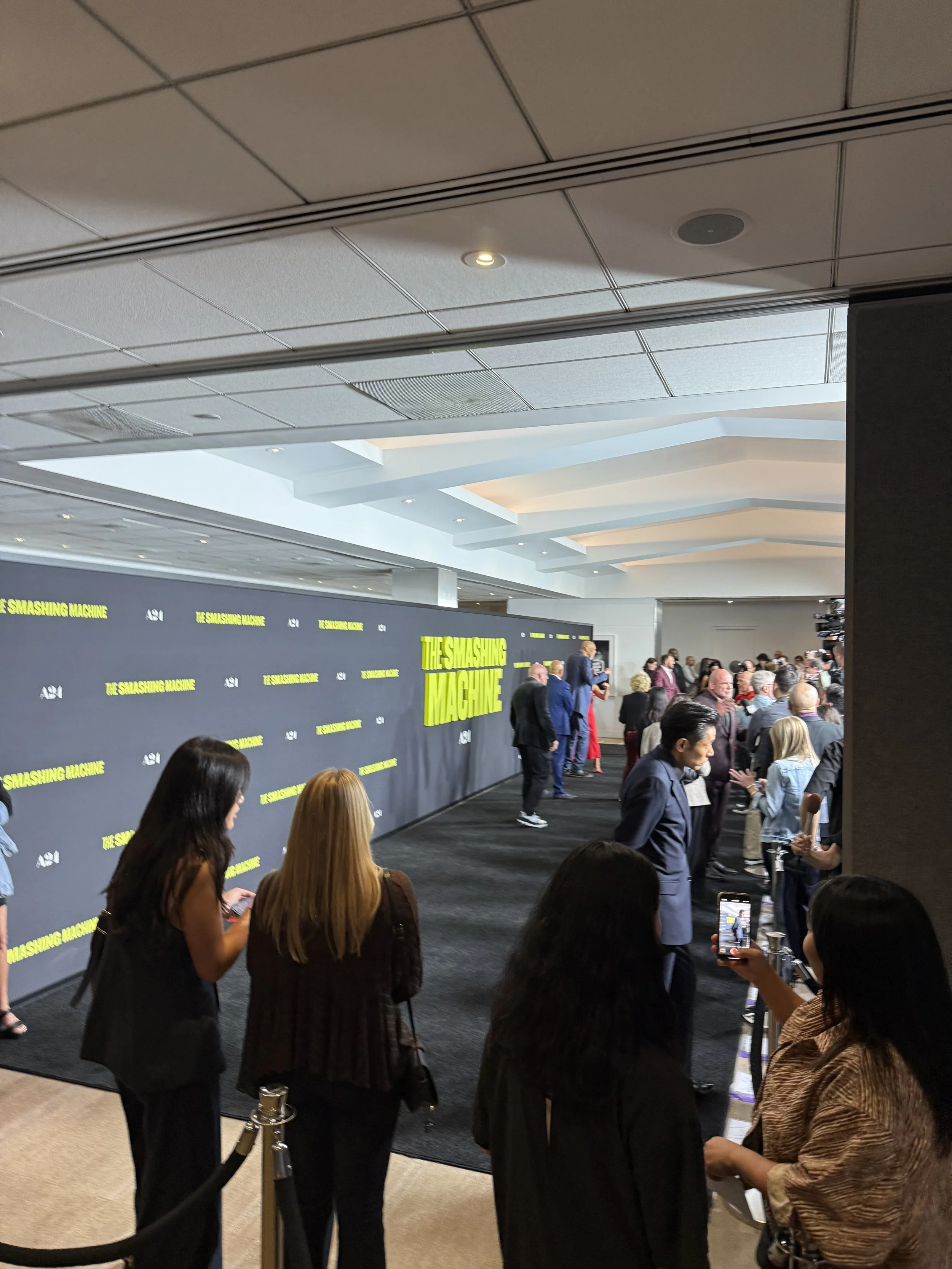  Red carpet with The Rock and Emily Blunt, film posters in the background.