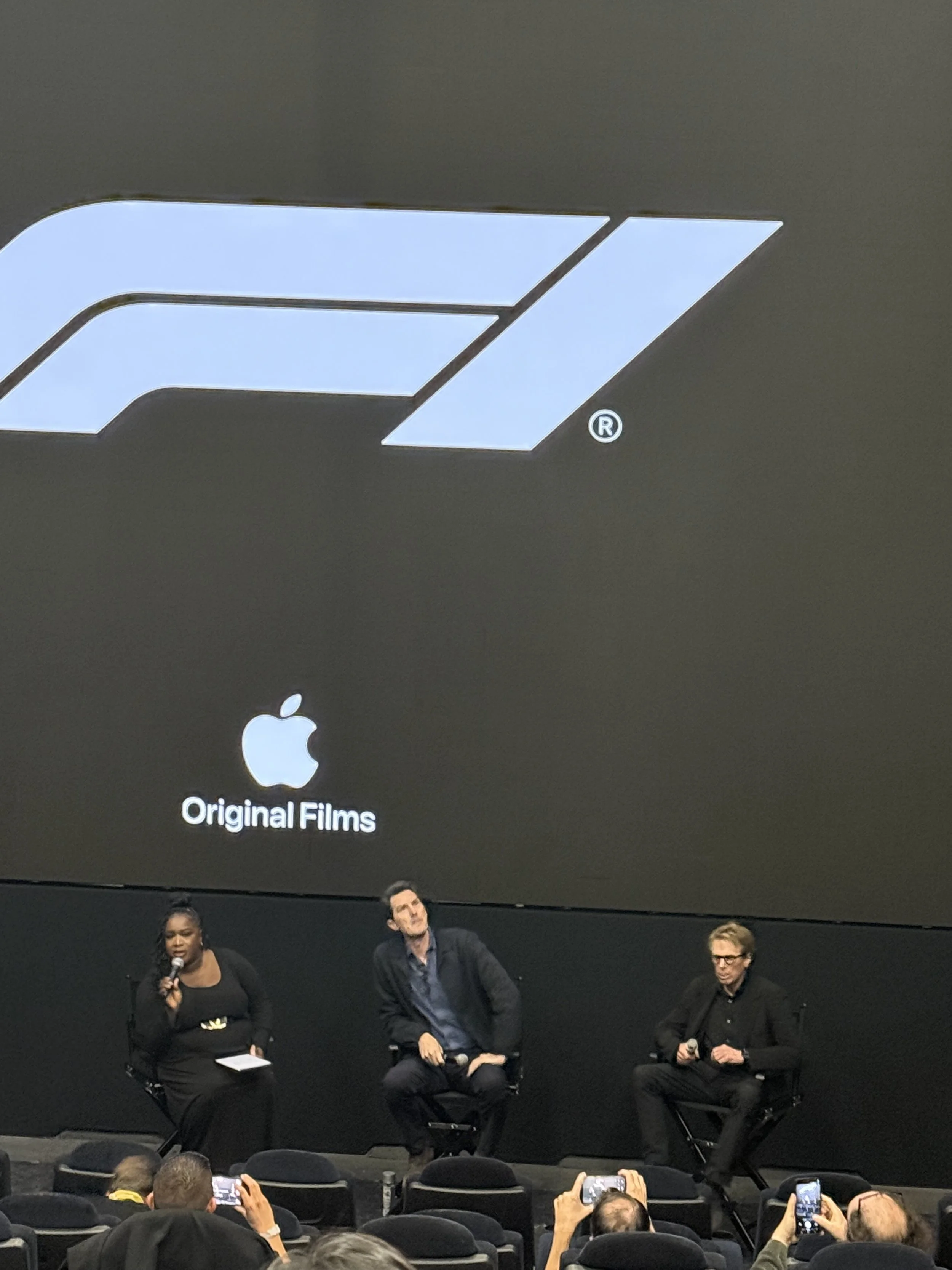 Big screen F1 setup, director and producer on stage.