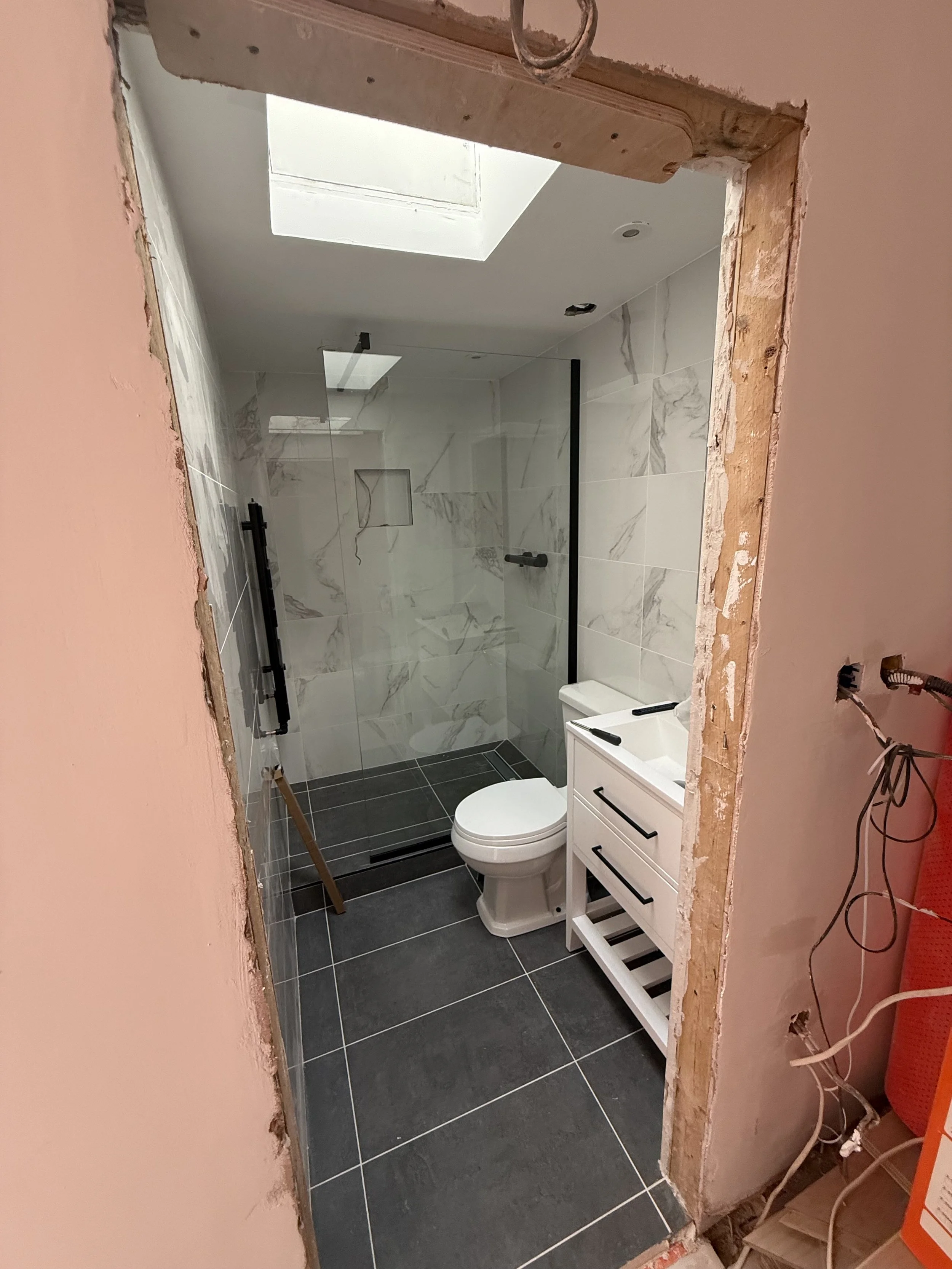 Complete bathroom with only a foot to get into the shower.jpeg