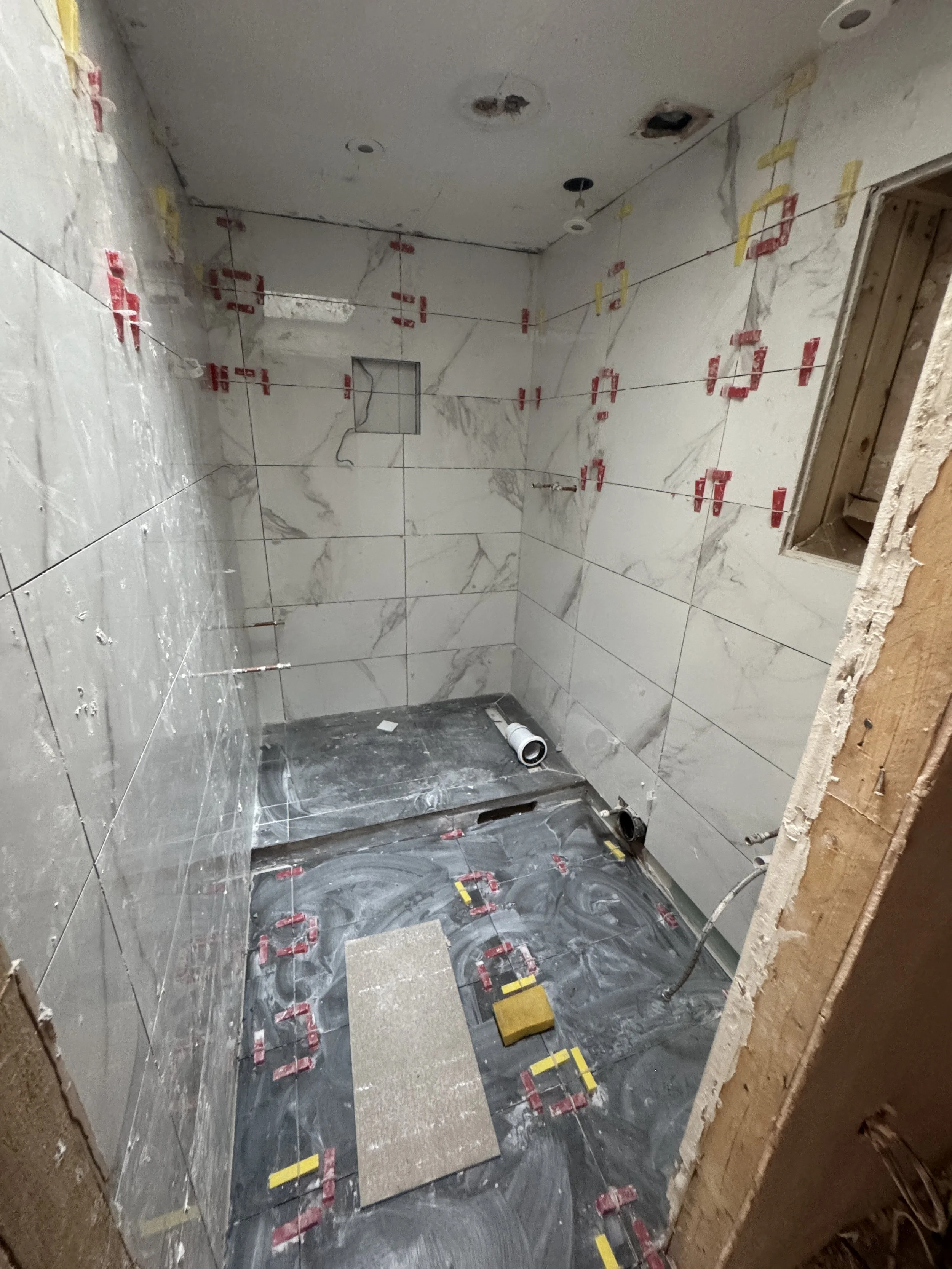 Bathroom fully tiled before they fell off the wall.JPG