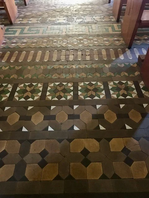  “Vintage brown and green geometric encaustic tile pattern in soft indoor lighting.”