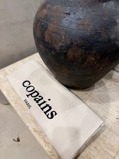 “Copain pastry bag with ceramic vessel on a pale stone counter in soft natural light.”