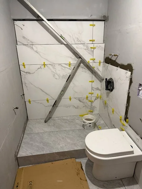 Shower wall alignment checked during bathroom rebuild