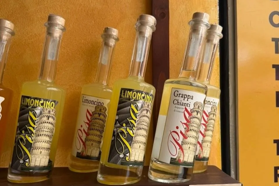 bottles of limoncino and grappa displayed on a wooden shelf