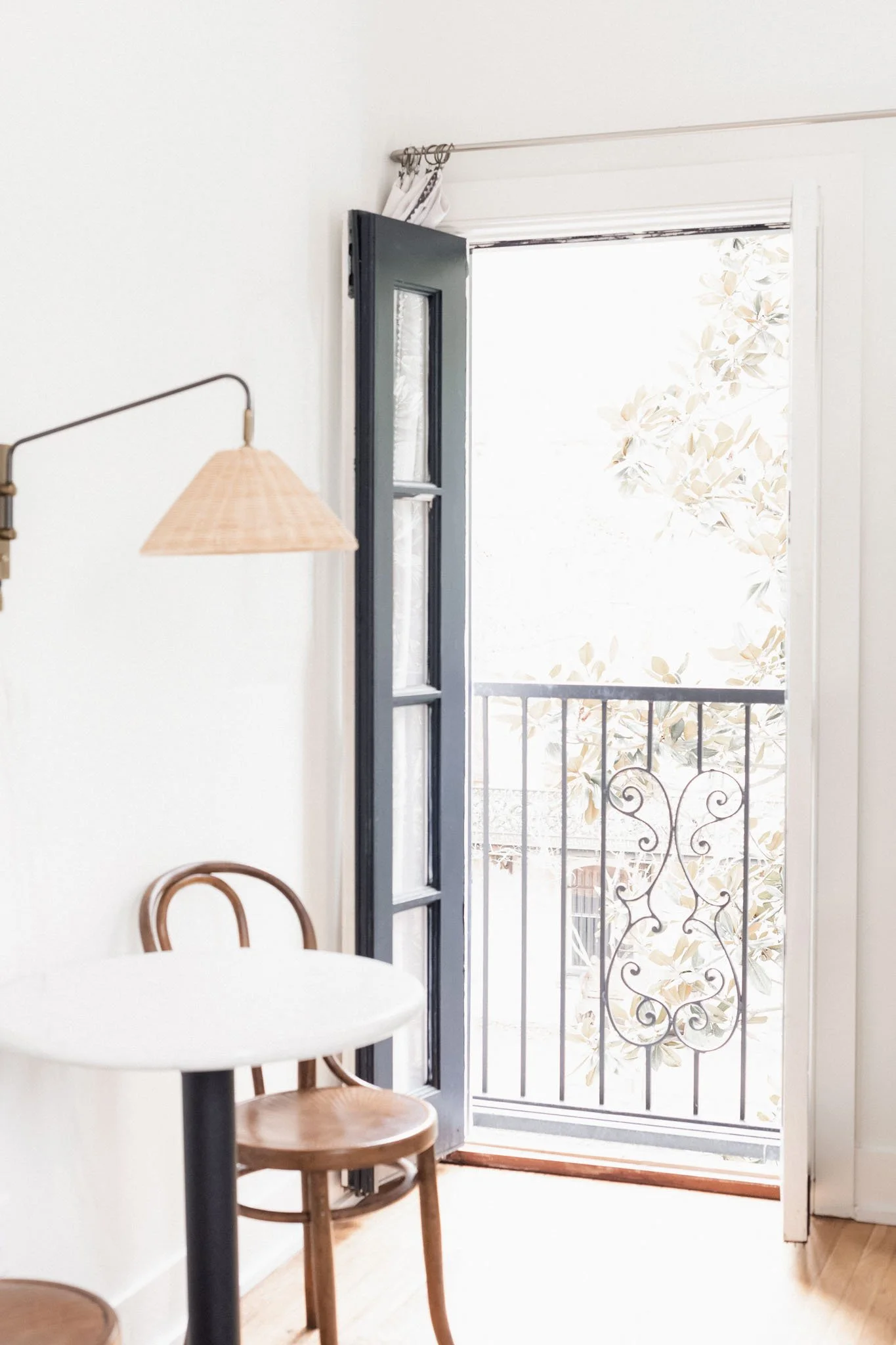 Bright interior corner with natural light pouring through an open doorway, minimalist furnishings and soft organic texture in a calm home setting.