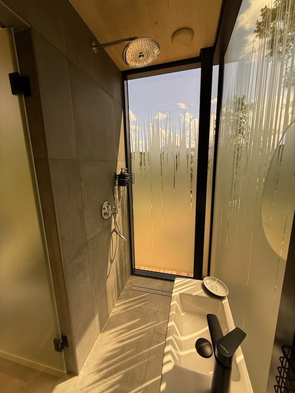 minimal shower room with frosted glass window and soft daylight in the ood house