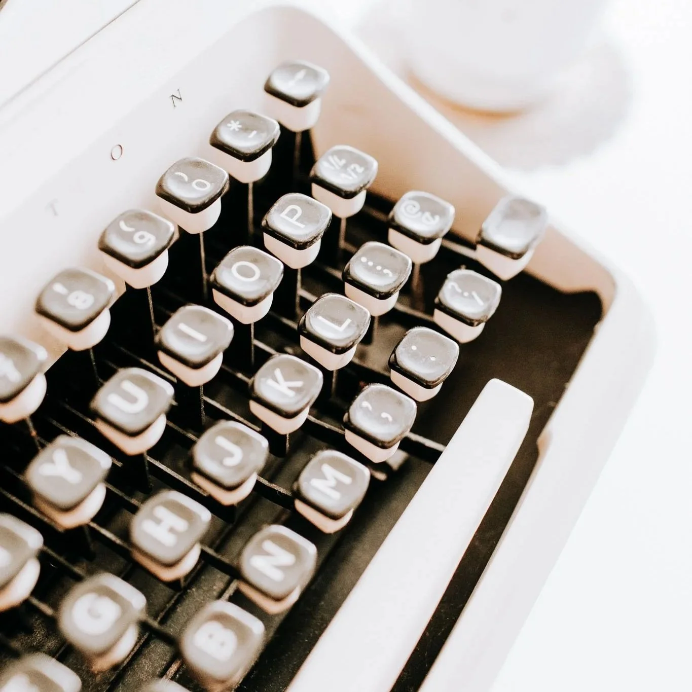 Close-up of a vintage typewriter and keys in warm light, symbolising slow, intentional writing and the craft of creative blogging.