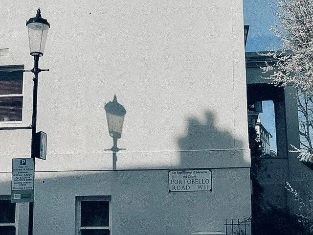 Soft winter light casting a lamp post shadow on a quiet Portobello Road façade