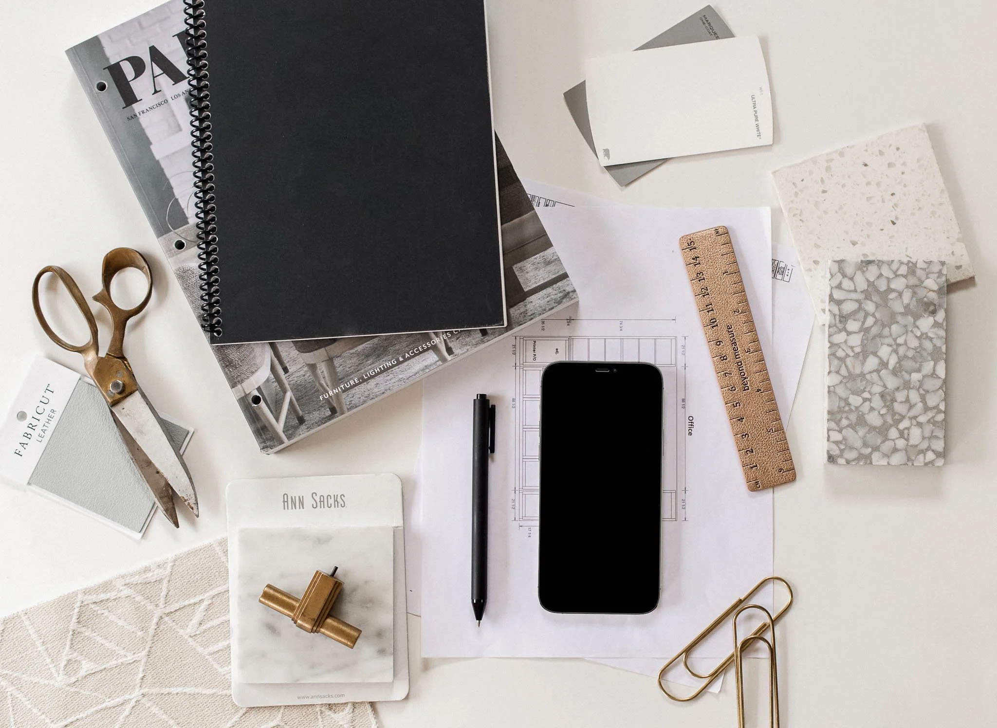 A clean renovation planning flat-lay featuring a ruler, tile samples, paint cards and architectural drawings — illustrating how order and priority shape renovation decisions.