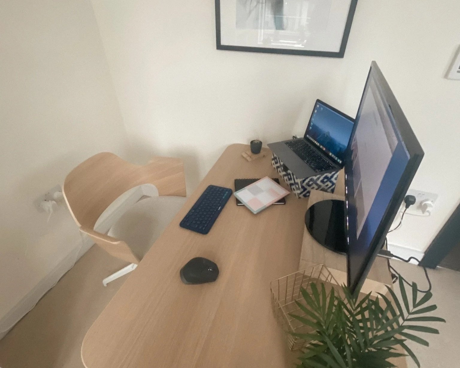 “Minimal bedroom workspace with a light wood desk, soft neutral tones, and natural daylight.”
