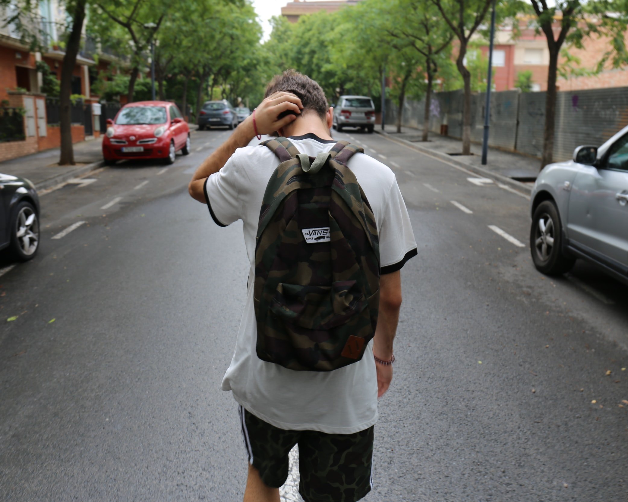 Boy Wearing White Shirt Standing in the Middle of the Street