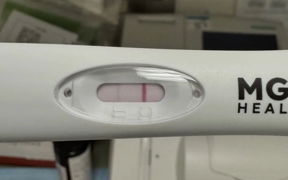 An ovulation predictor kit result window showing one faint line (test response) and one dark line (test control)