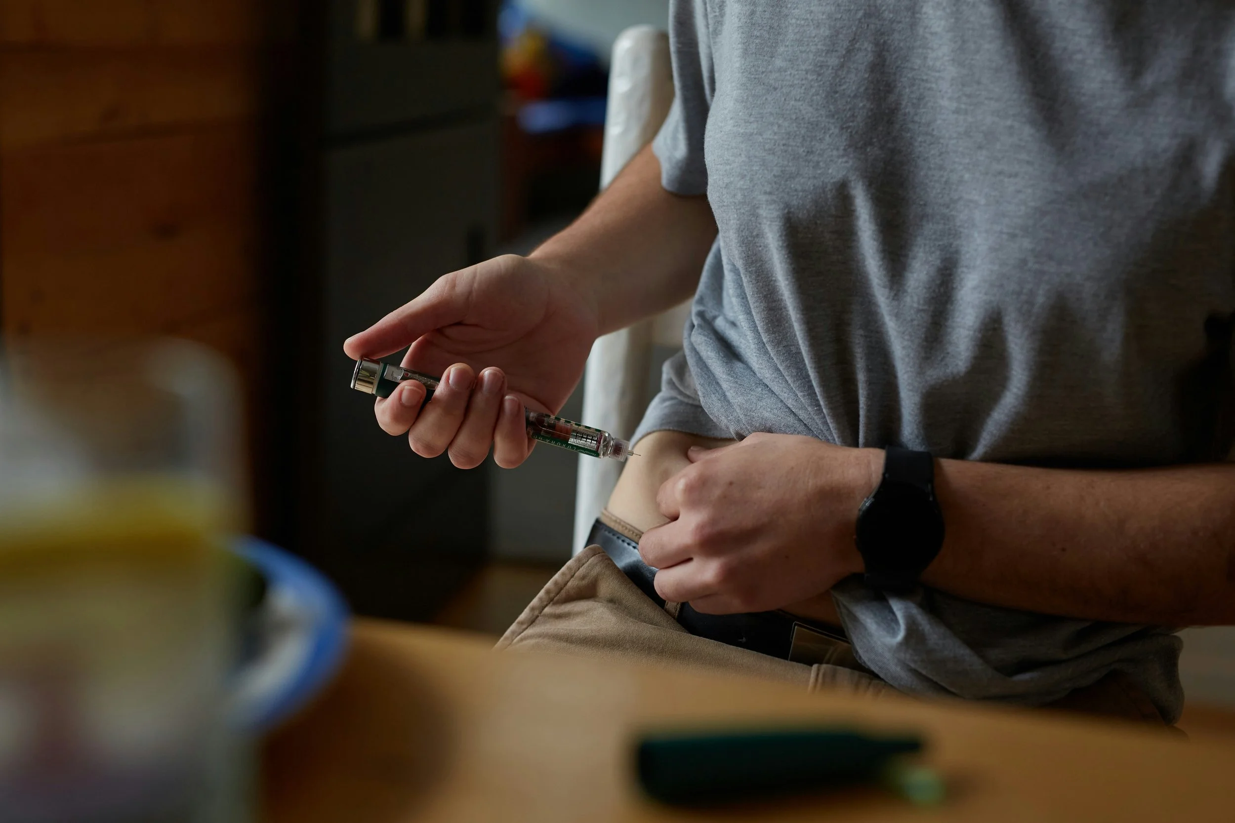 A person using an injectable medication in their abdomen