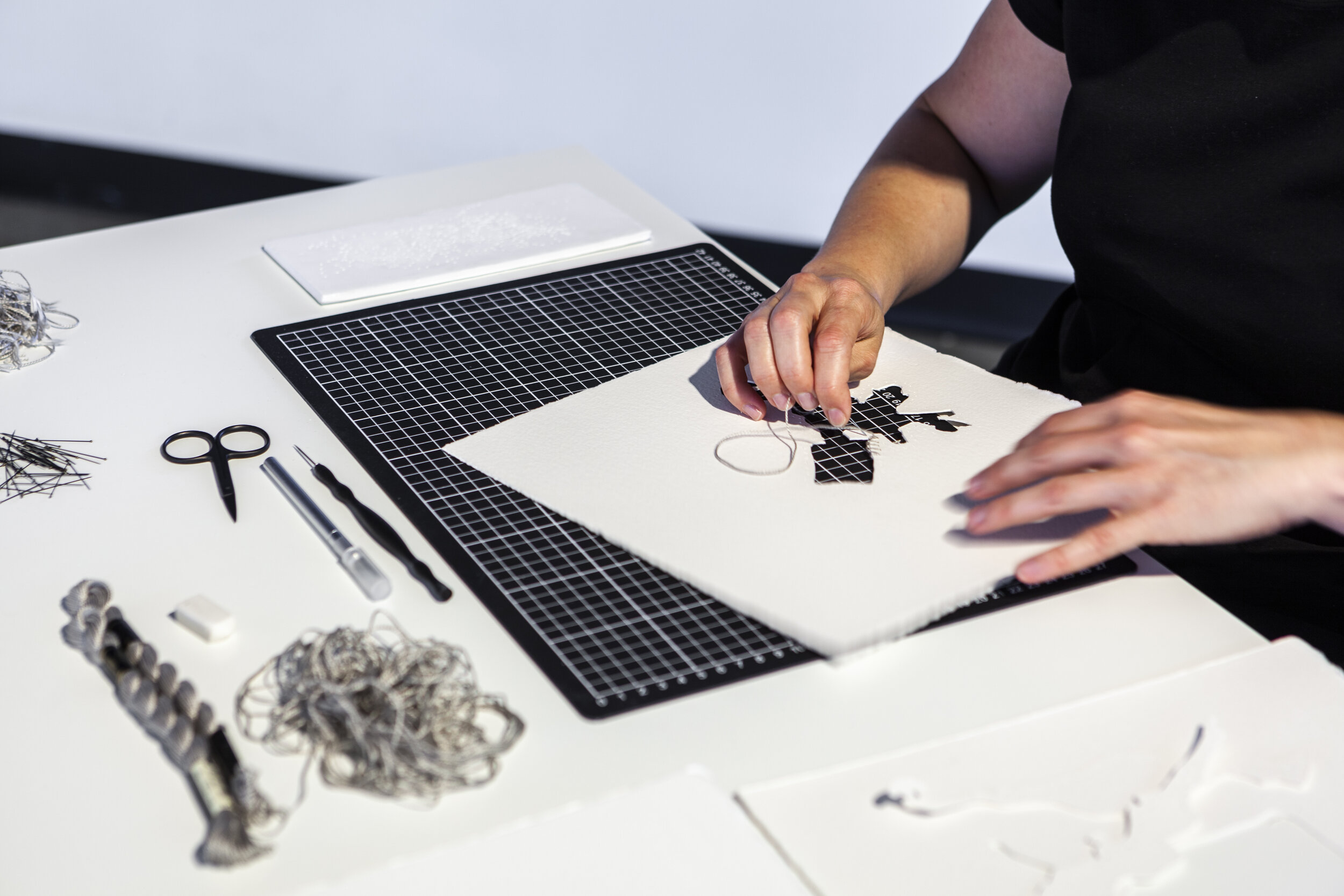 Niomi Sands, where the lost things go, 2019, cotton, Arches paper, entomology pins, table, stool and sewing equipment (performance detail, Grey Street Gallery QCA) Courtesy of the artist. Photographer Andrew Willis
