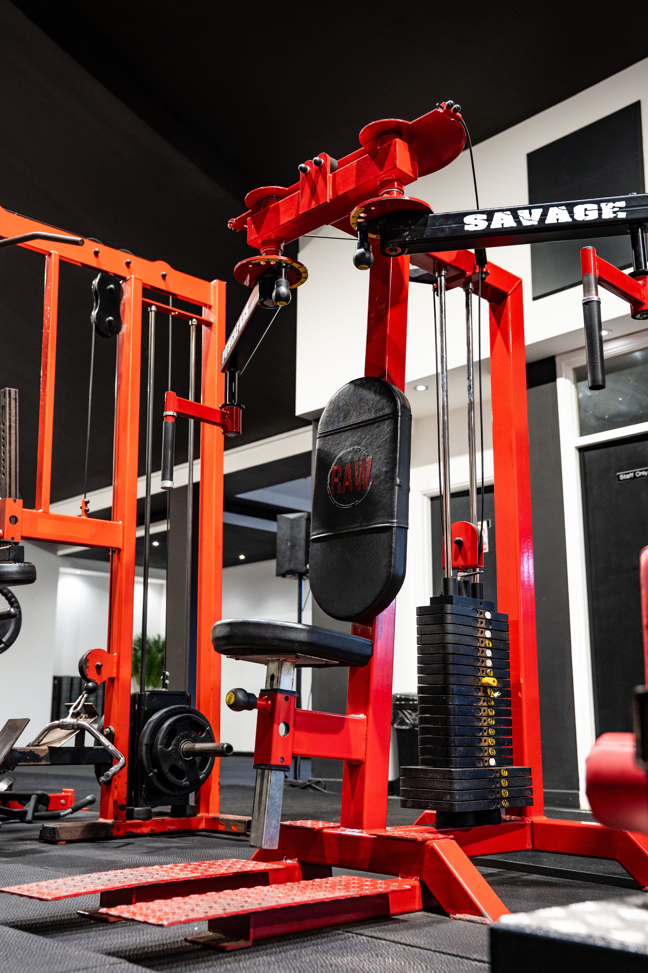 Red and black weightlifting and exercise equipment in a gym.