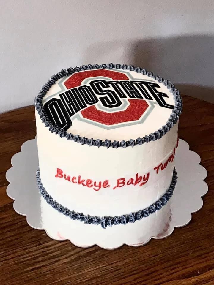 Cake decorated with "Ohio State" logo and "Buckeye Baby Turn" text on white icing.