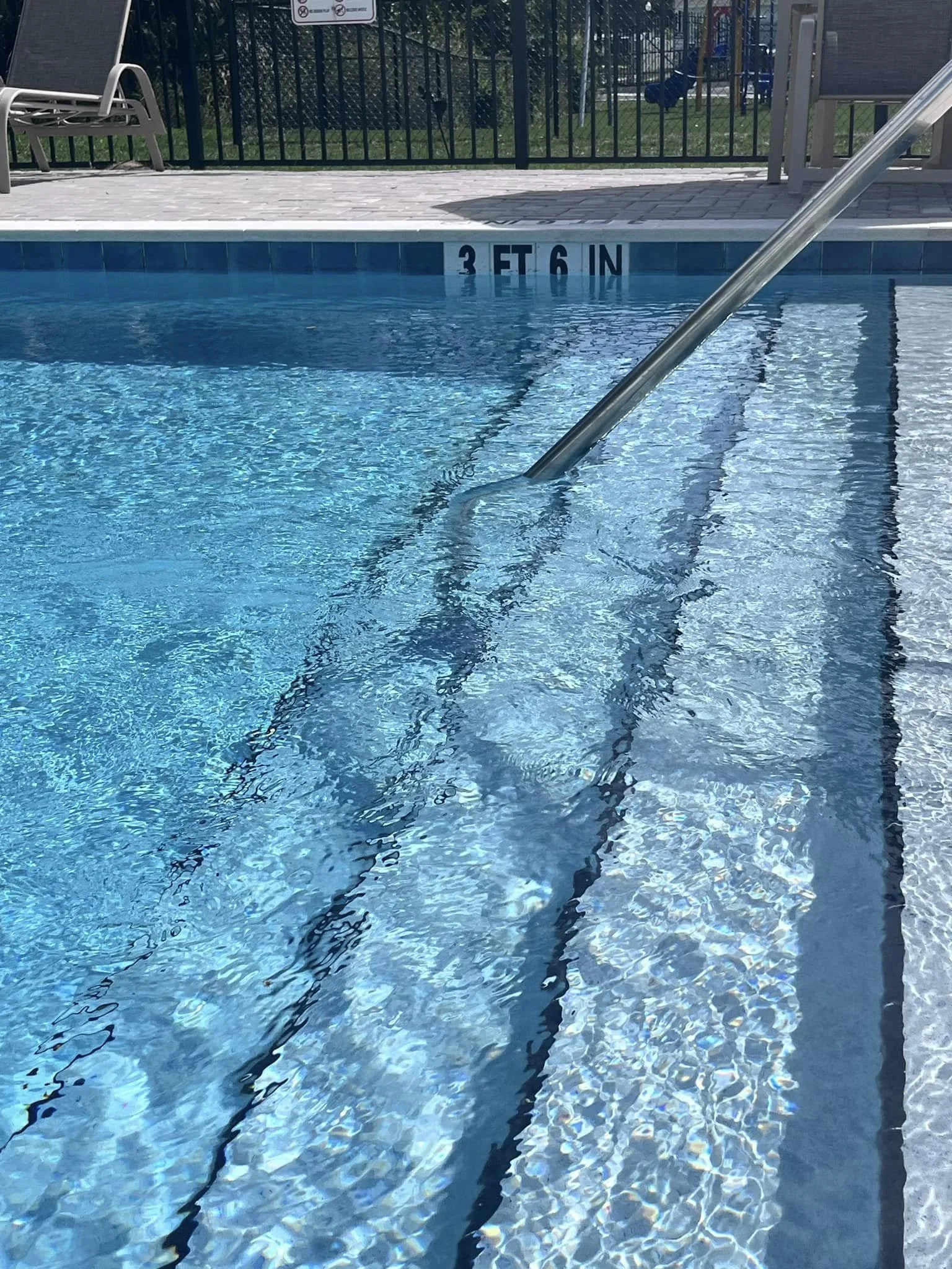 Swimming pool with a metal handrail and water marked at 3 feet 6 inches deep.
