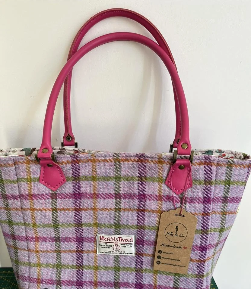 A photo of a pink/multi Harris tweed bag