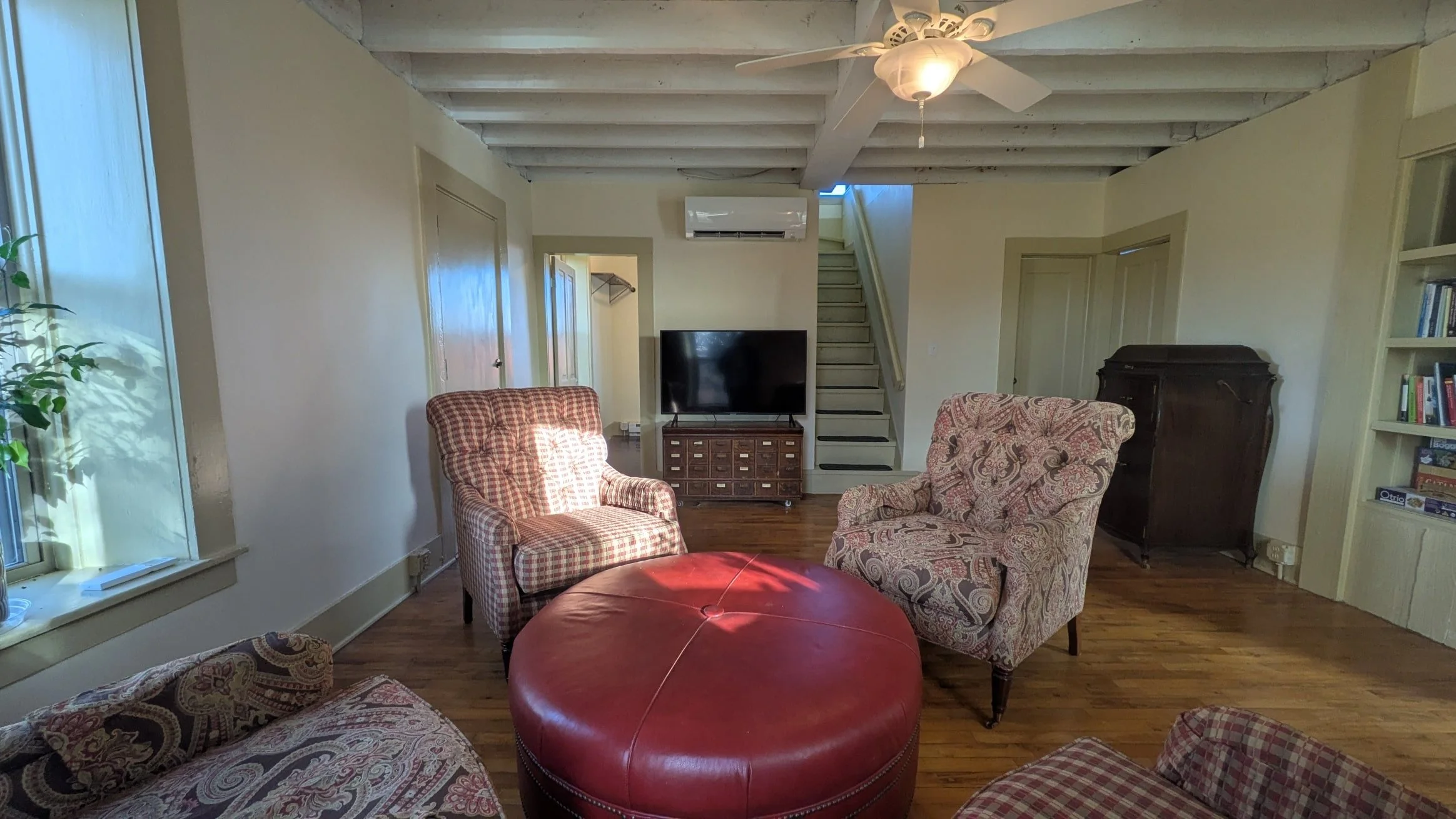 Photo of the living room facing the TV and staircase.