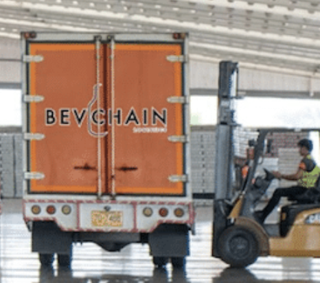 A delivery truck with an orange back doors labeled 'BEVCHAIN' and a person operating a forklift nearby.