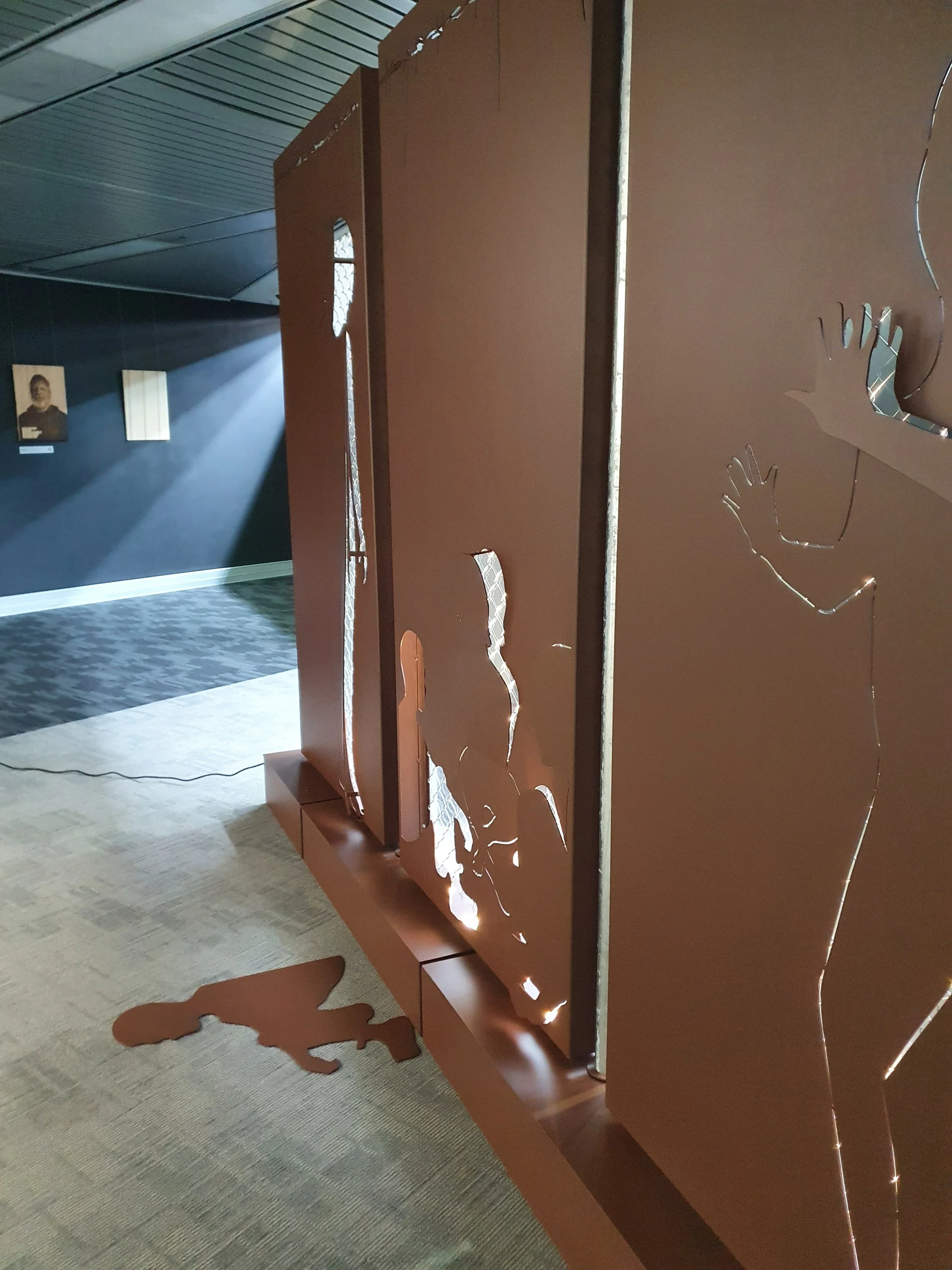 Detail of Limen exhibition panel with figures