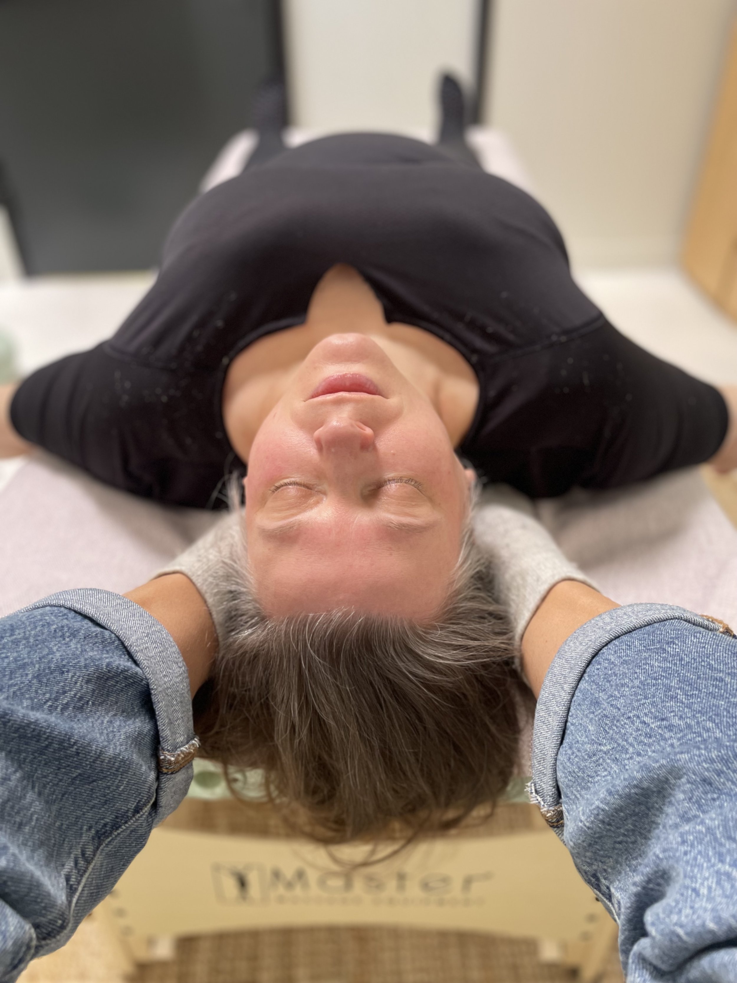 Feet gently lifting trapezius muscles on massage table