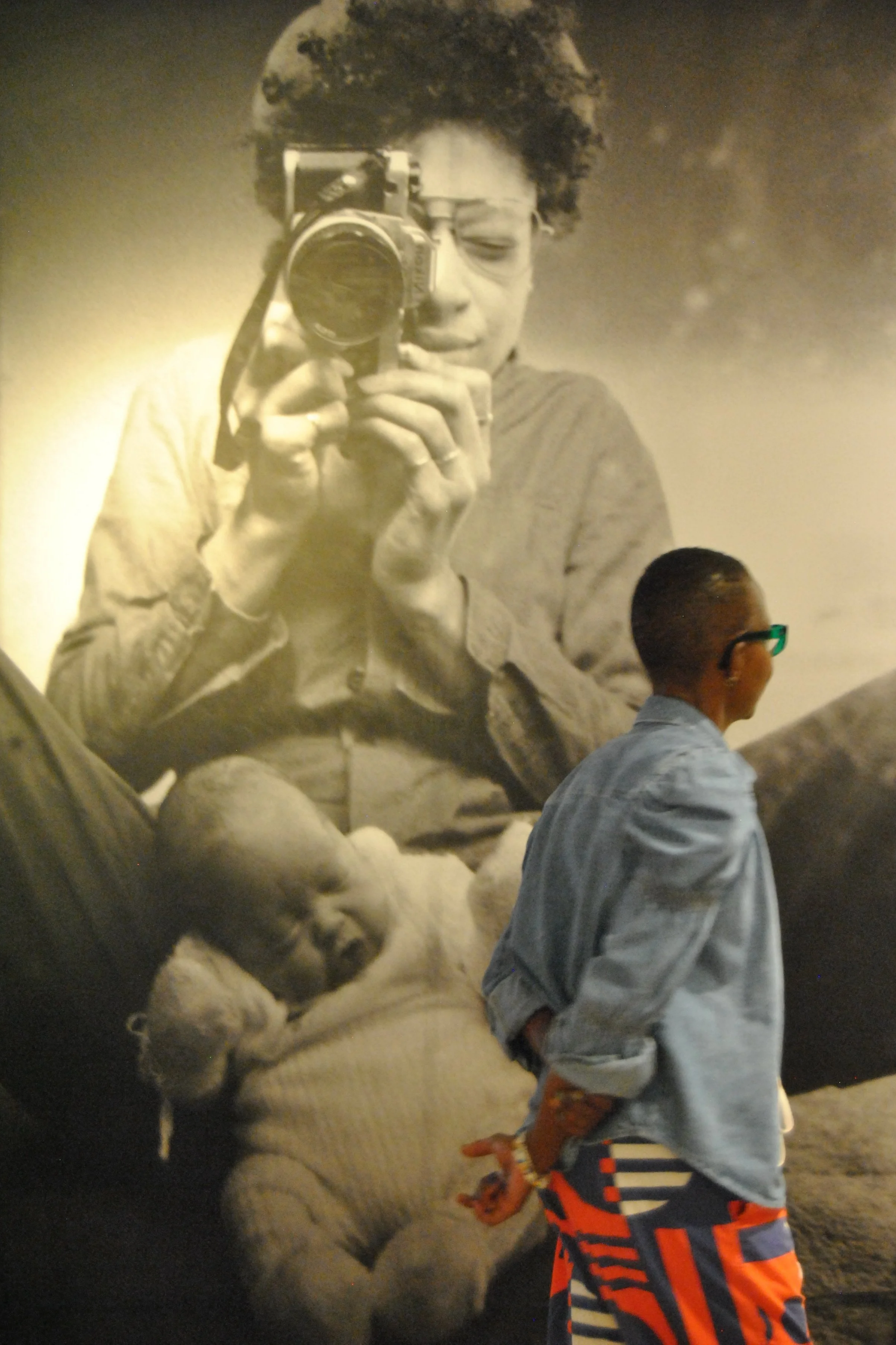 The giant photo print of baby Tyler sleeping between Sandra's legs, with a friend from the group walking past to show perspective