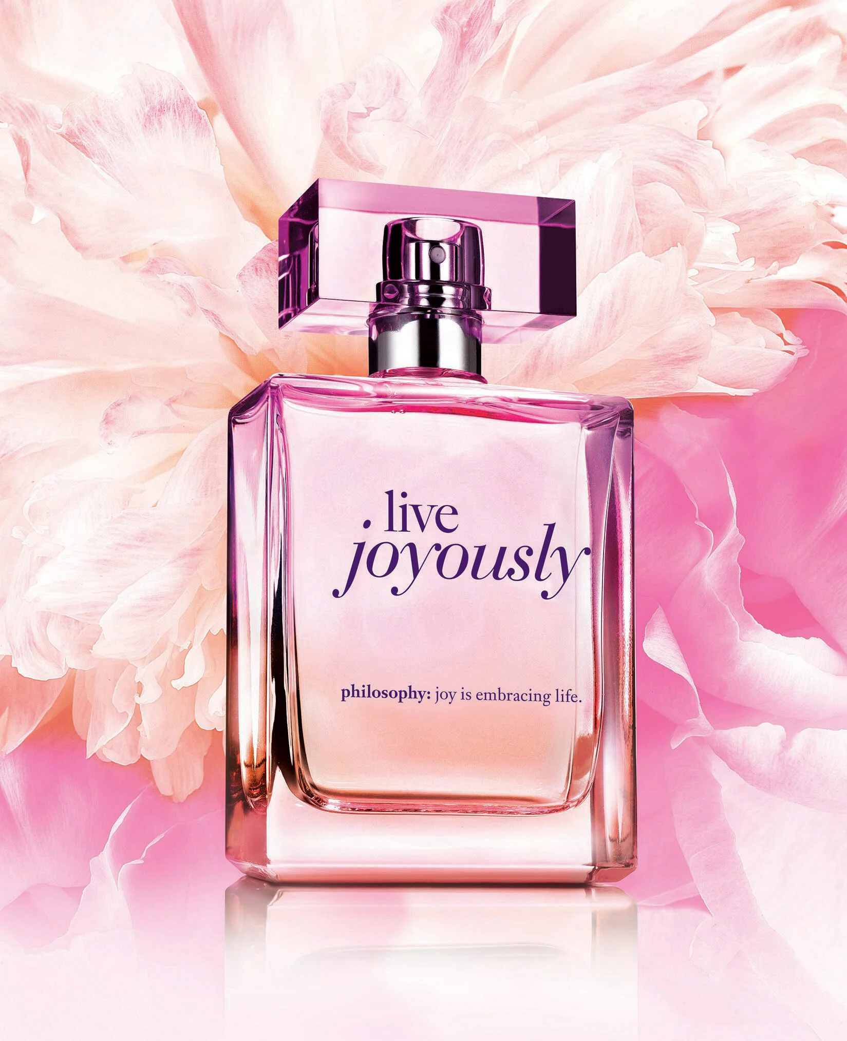 Perfume bottle with "Live Joyously" text on floral pink background.