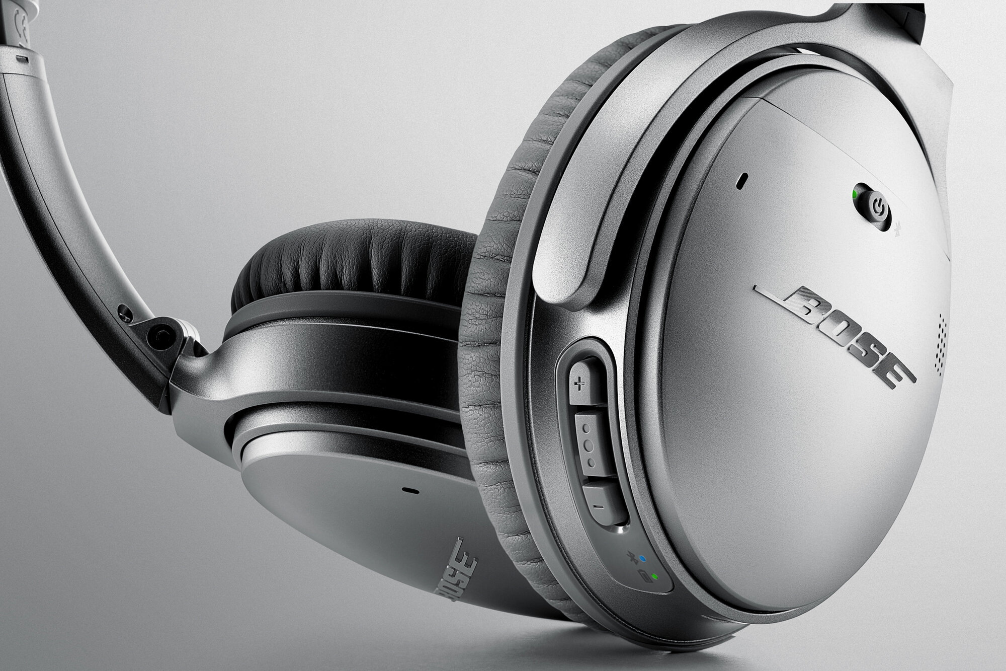 Close-up of Bose noise-cancelling headphones on a gray background.