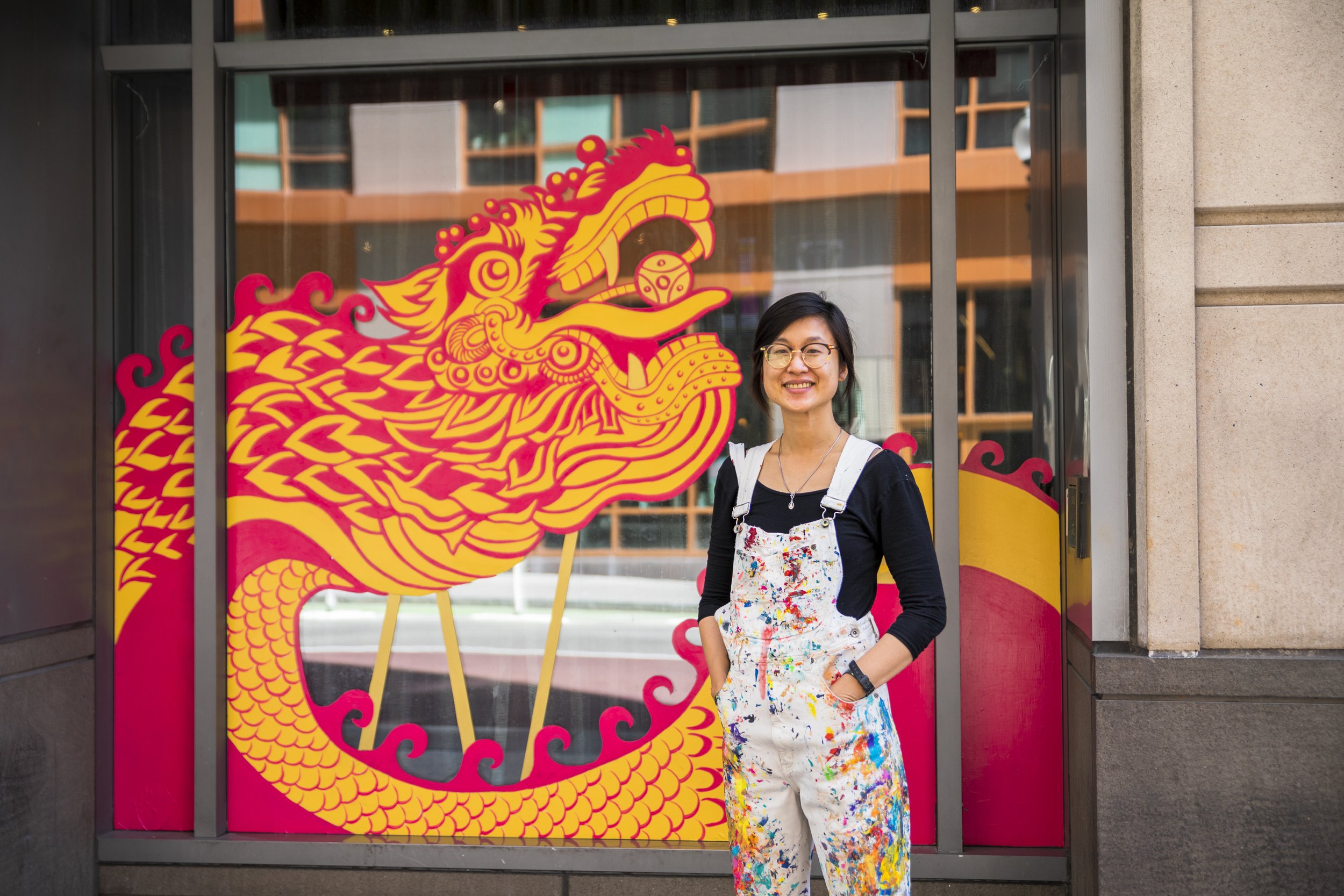 Ponnapa Prakkamakul in front of her mural, "Together Everywhere," at Q Restaurant