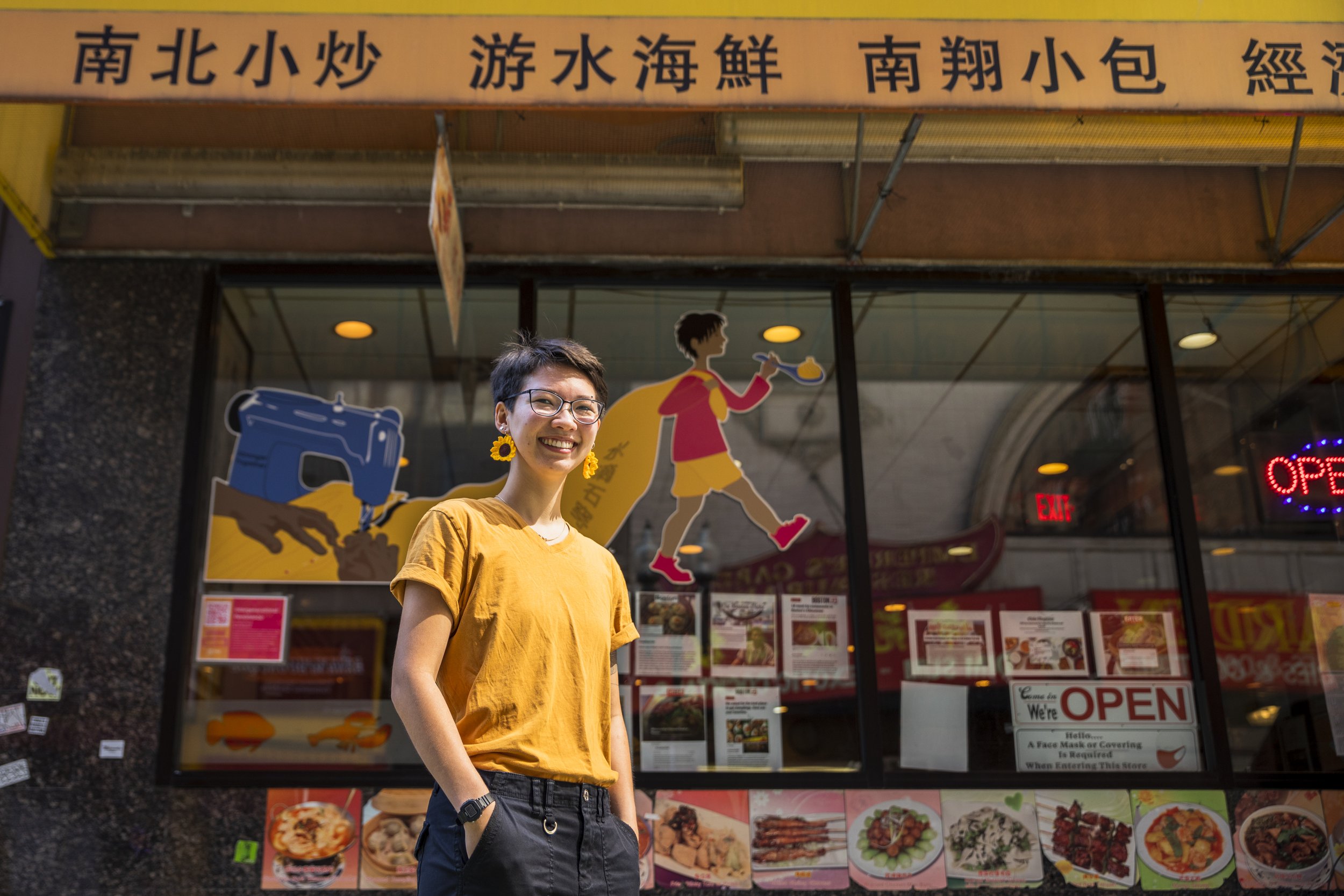 Maria Fong in front of her mural, "Intergenerational Persistence," at Dumpling Cafe