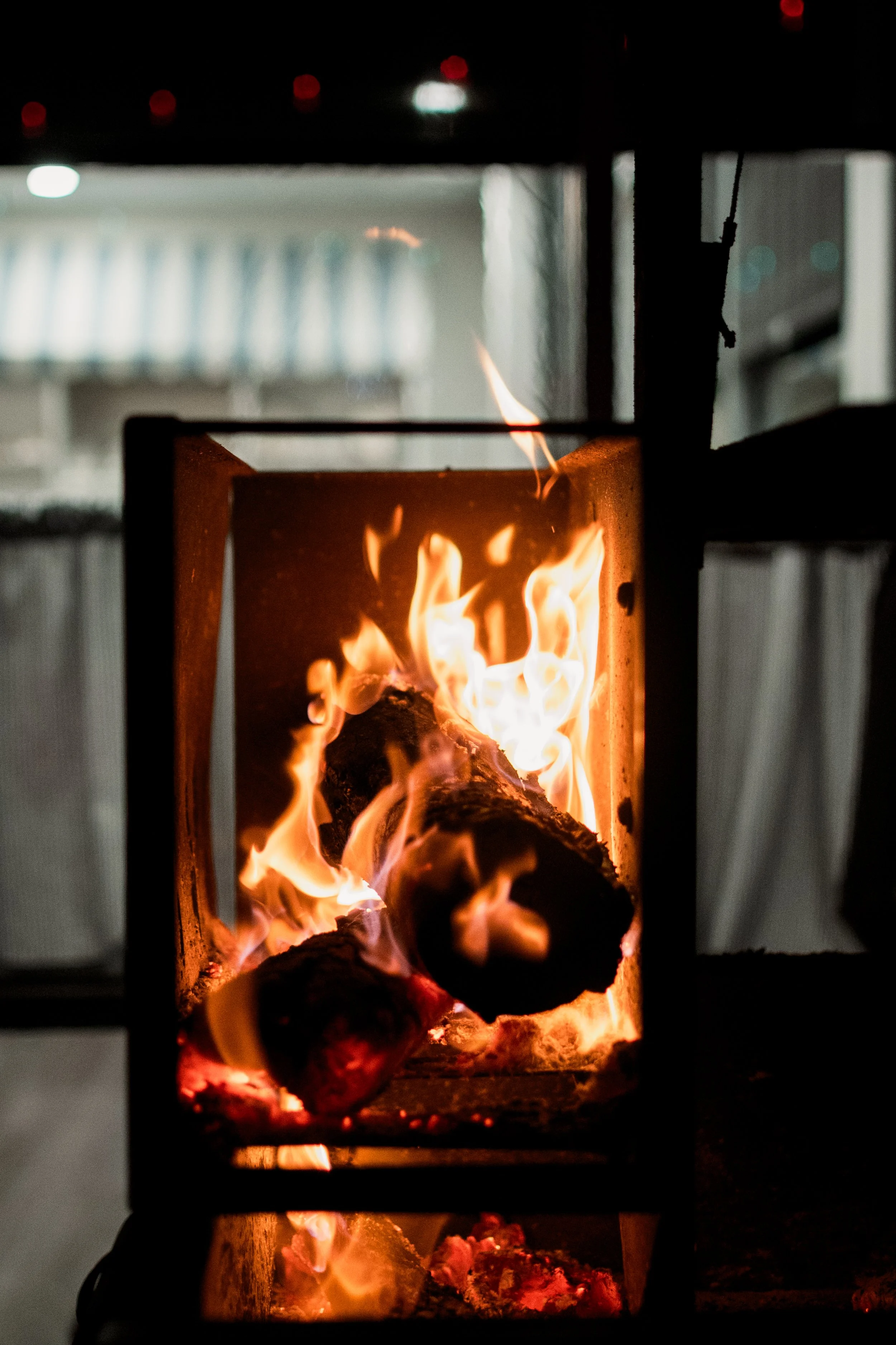 Clothes drying inside an indoor heater, with visible flames and glowing coals.
