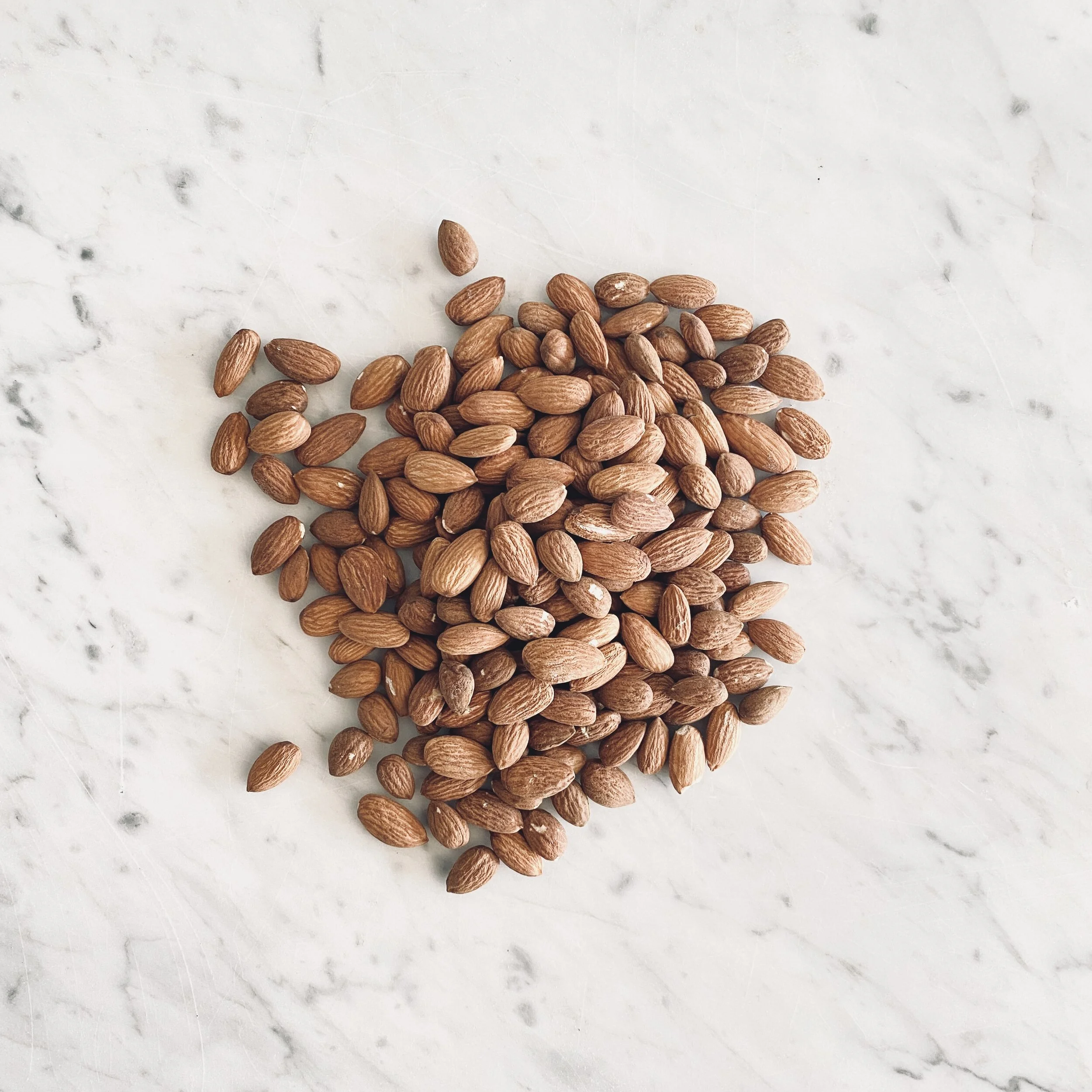 raw almonds on marble table