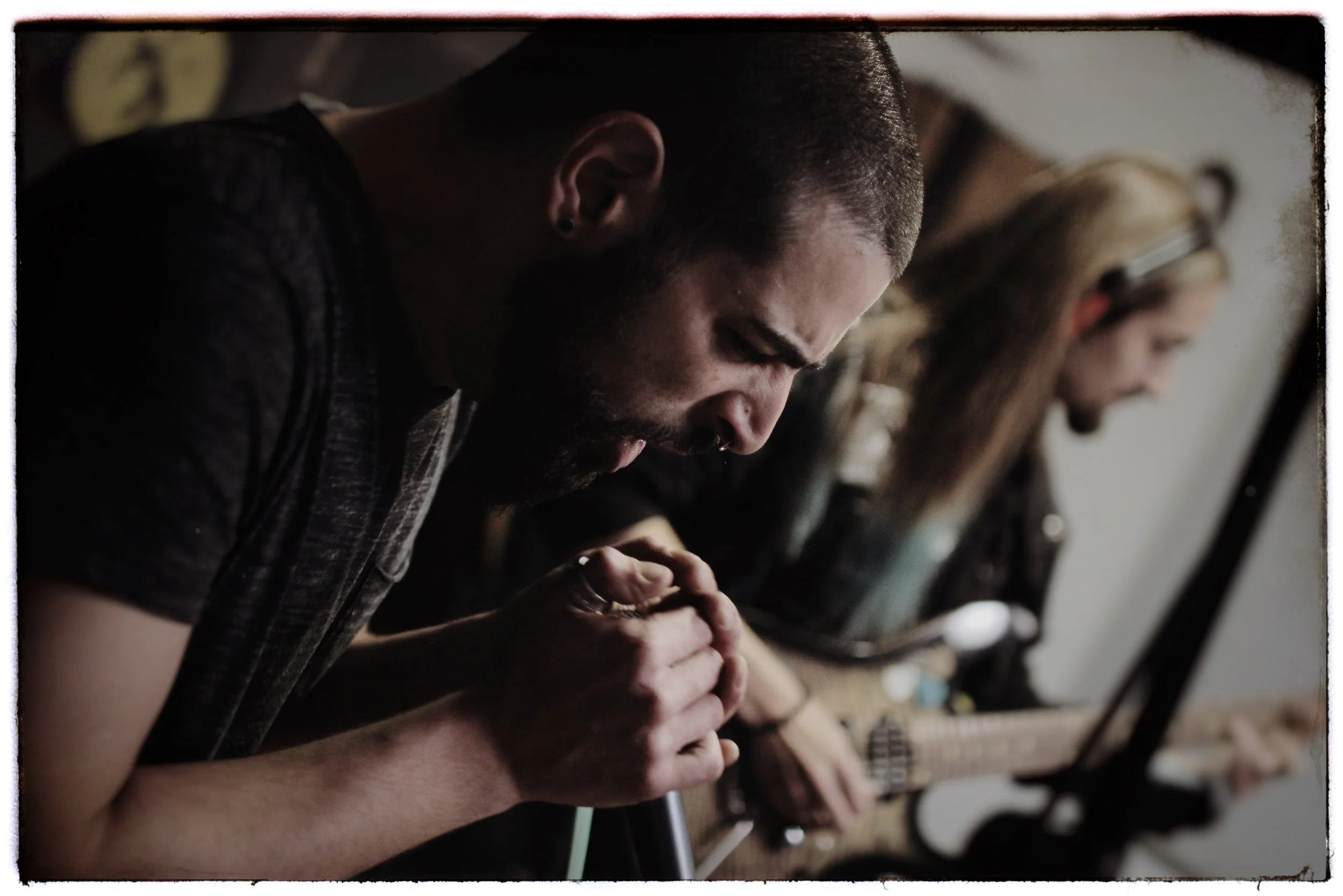 Close-up of multiple people sitting at a table with their hands clasped together in prayer.