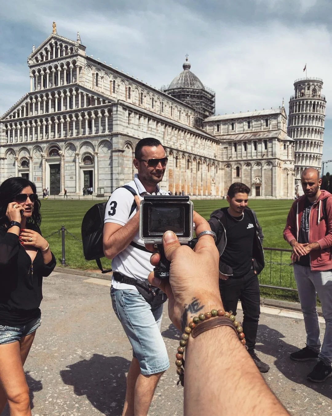 Tourists taking pictures in front of the Leaning Tower of Pisa in Italy.