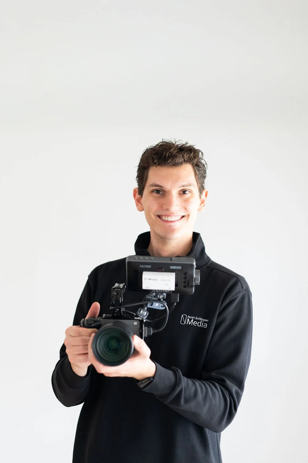 Smiling videographer holding a professional video camera at an Illinois Local member photo shoot