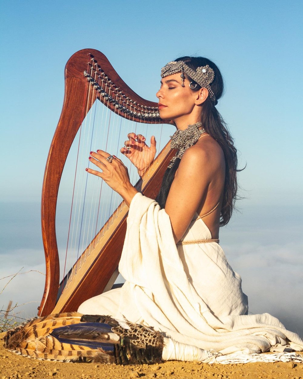 Scarlett playing harp above the clouds