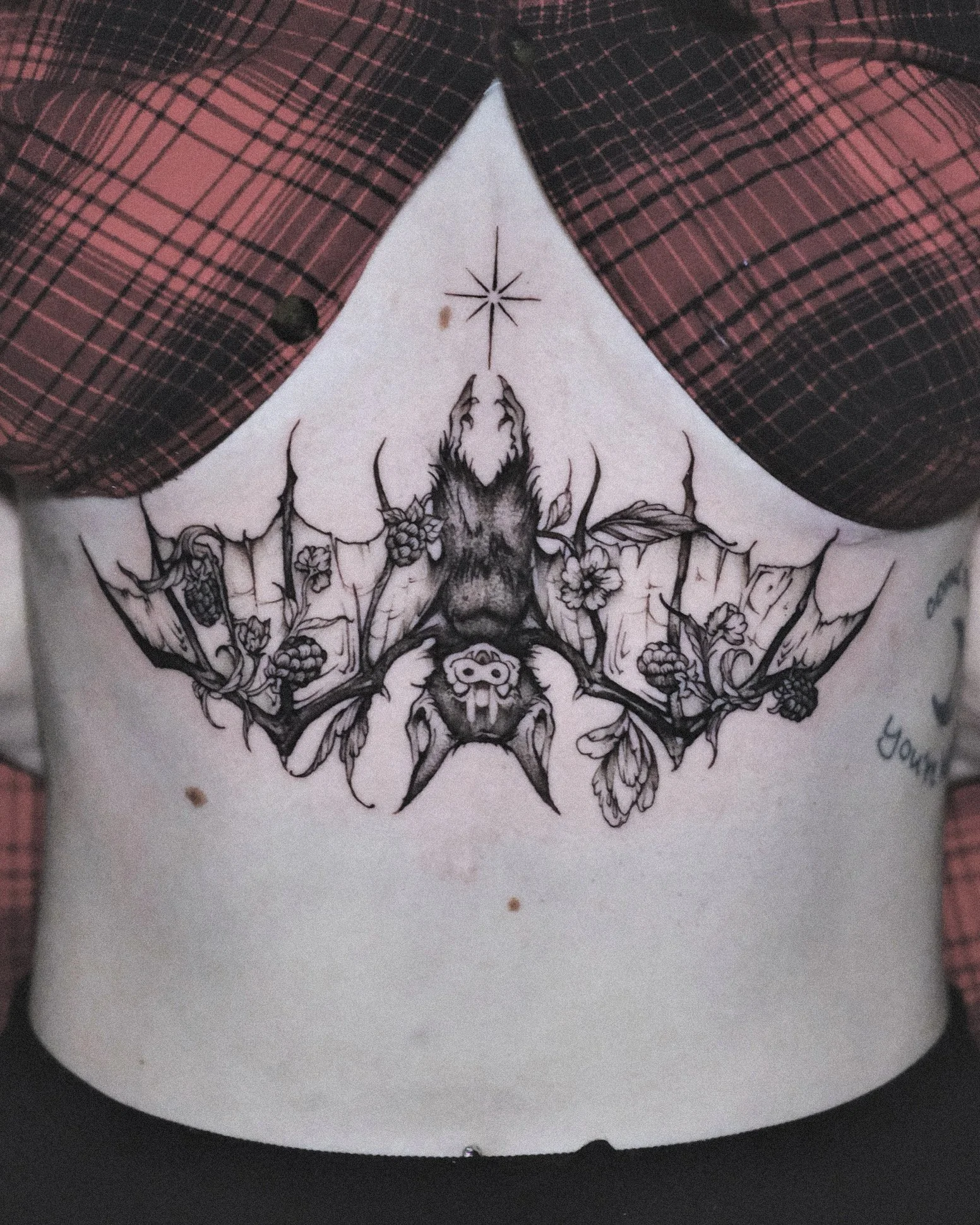 blackwork feminine bat tattoo design on a sternum by Cayla Myers at Hell Bunny Tattoos