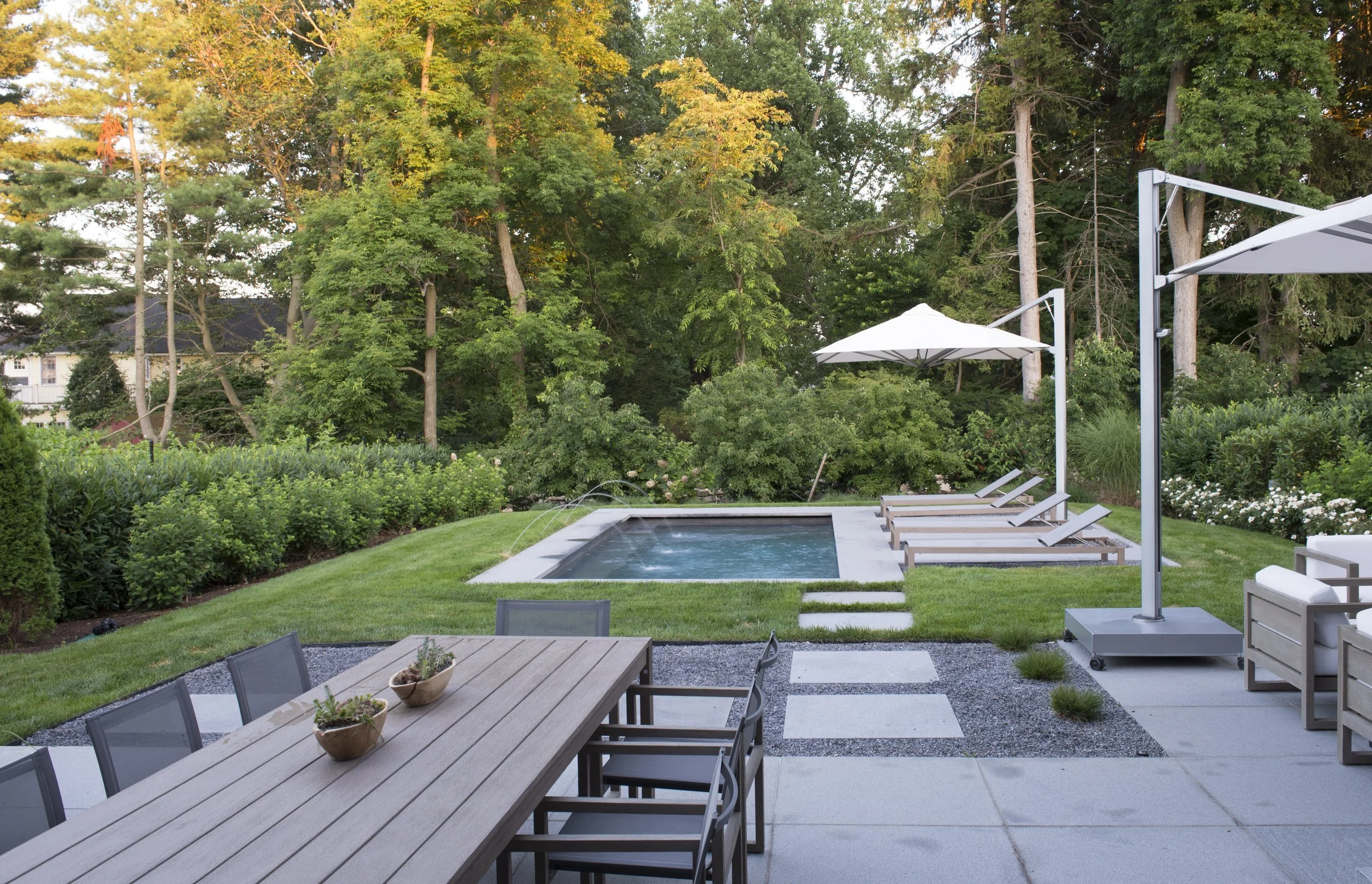 Outdoor dining table looking across stepping stones to the pool