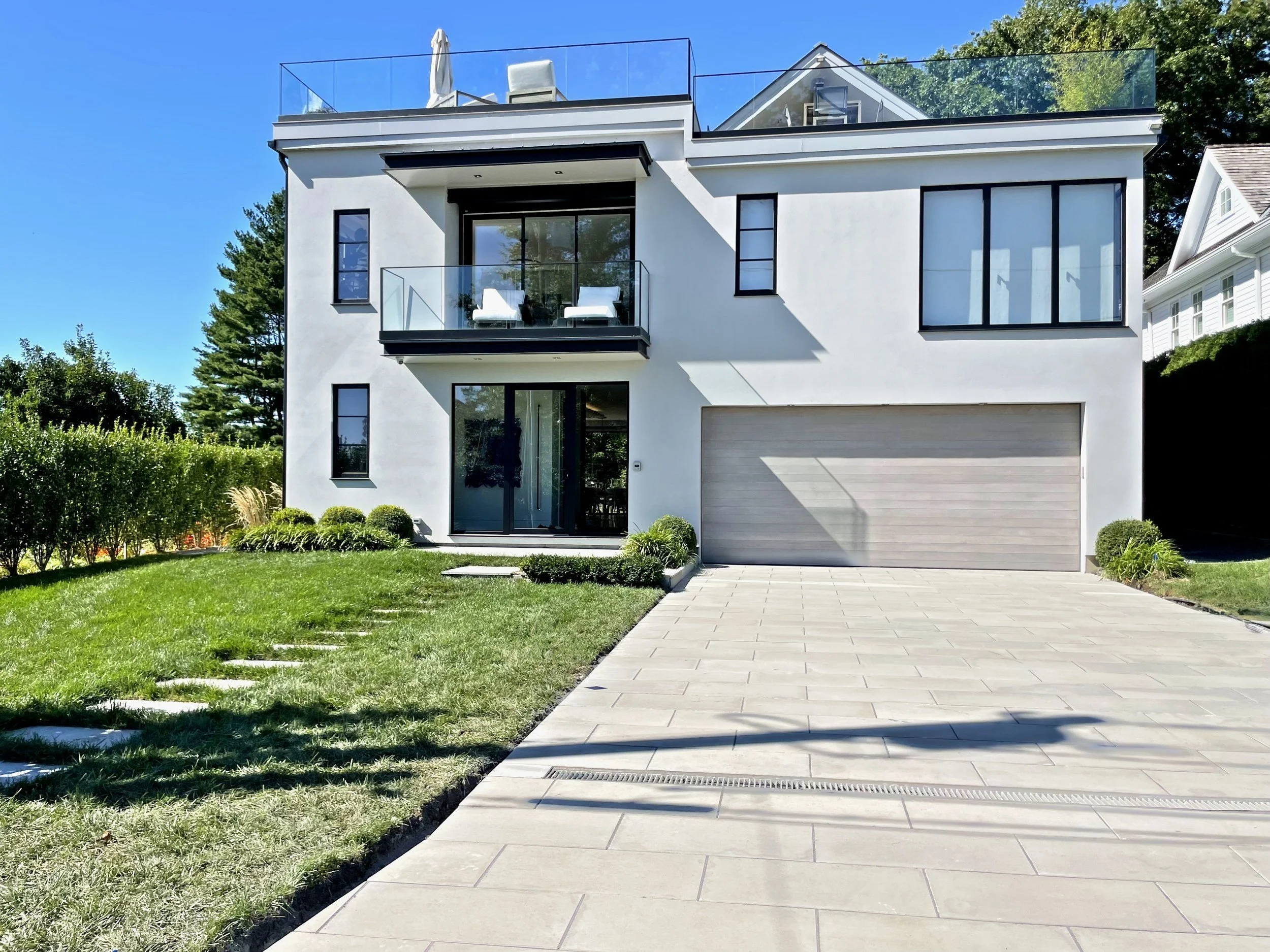 Modern white house with a pale stone driveway and lawn