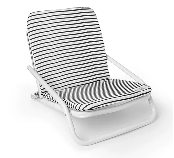 A white outdoor lounge chair with black and white striped cushions.