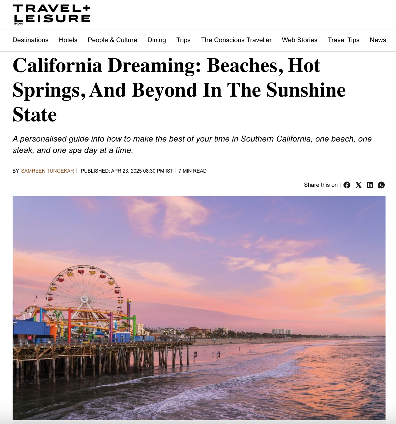 Sunset at a beach with a pier, colorful amusement park rides, including a Ferris wheel, and buildings in the background.