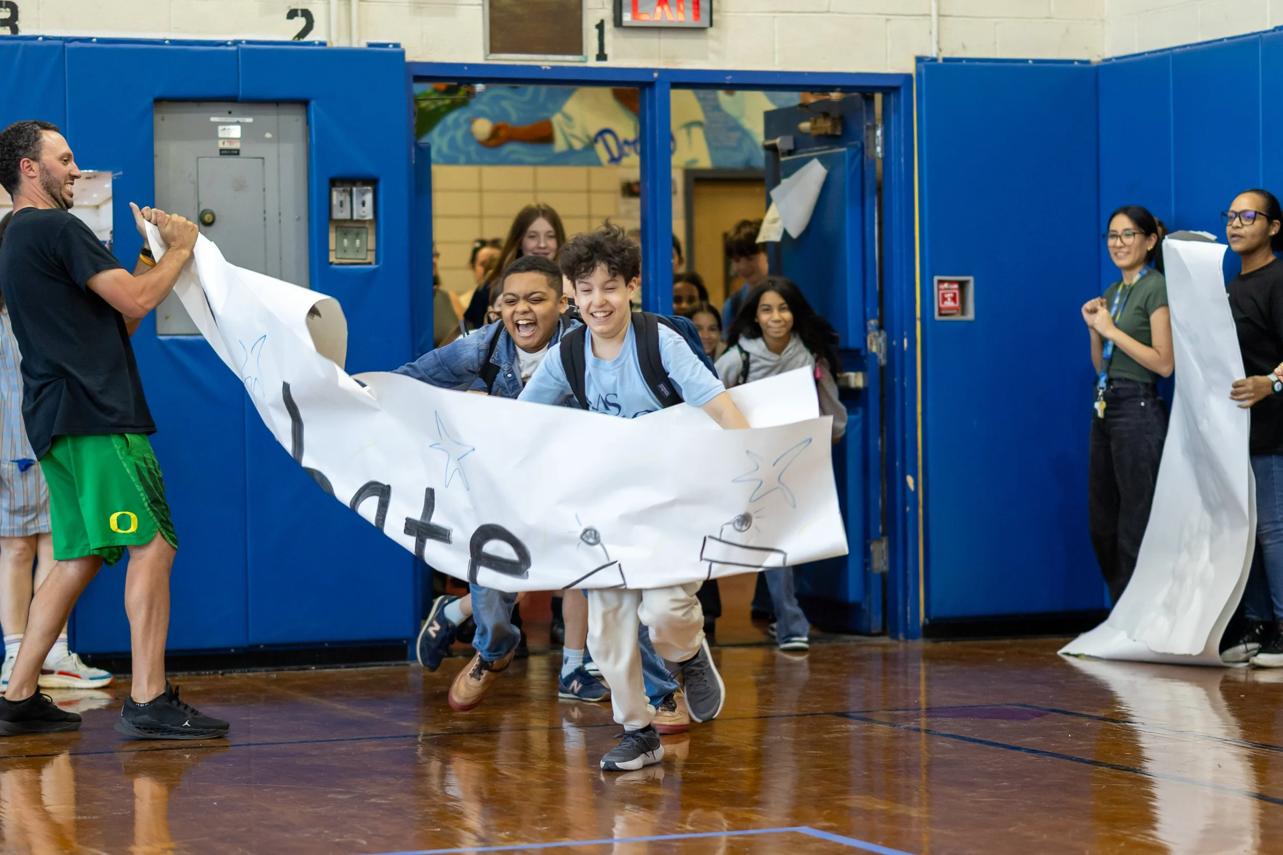 Students run through banners at pep rally