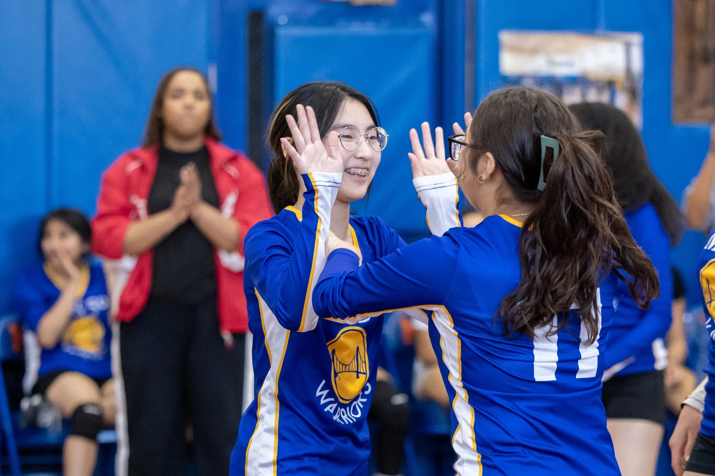 students high five in volleyball game